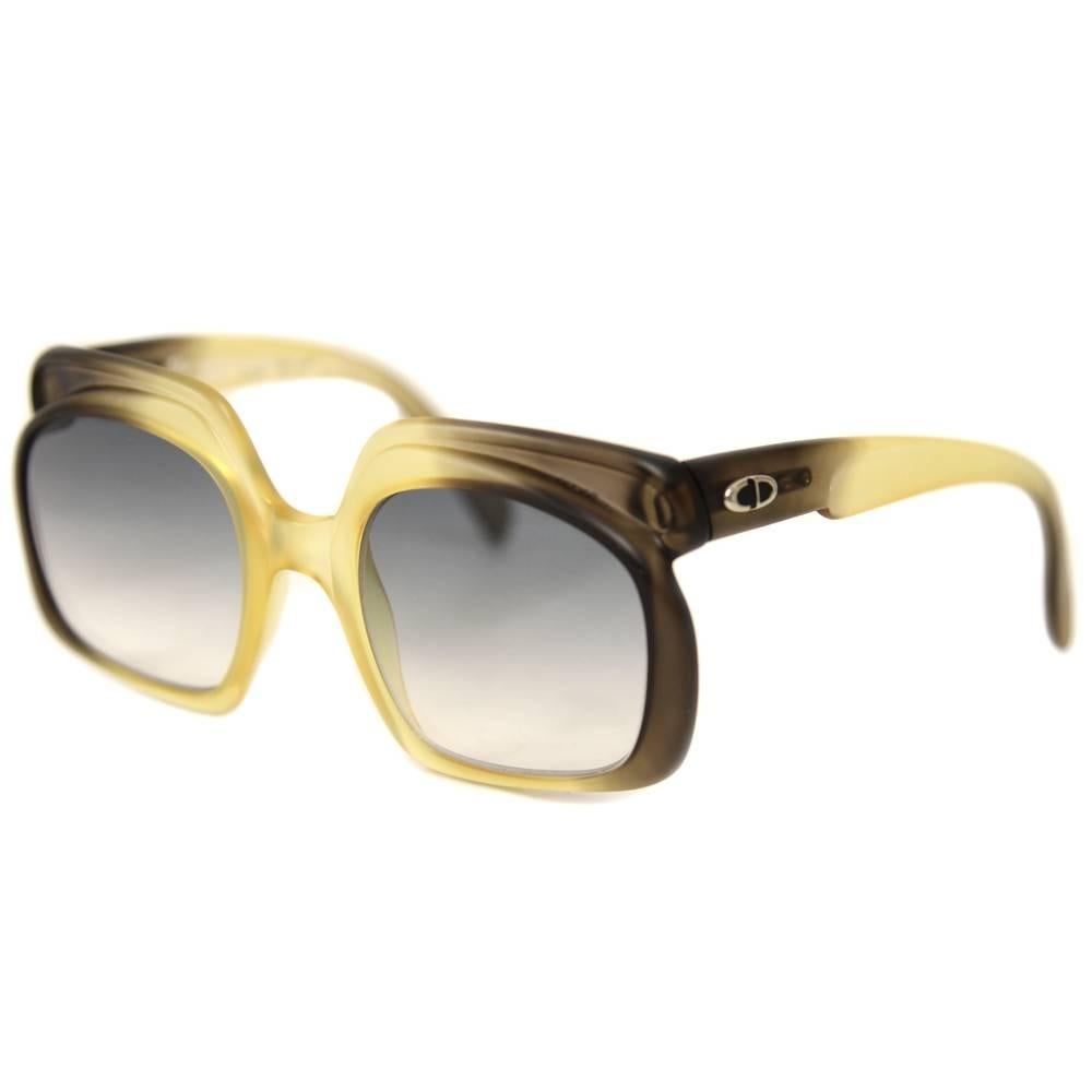 These Christian Dior sunglasses from the Seventies have such a forward-looking shape. The opaque faded yellow and black frame has a soft rounded decoration on top, while the lenses have a chic faded bright blue colour. Good conditions.
This item