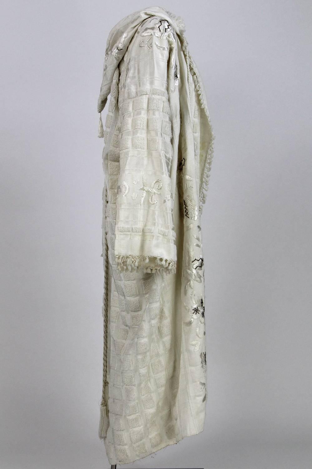 Unique hand-embroidered caftan in white embroidered cotton from the Nineties from South East Asia. Features beautiful white and golden floral embroideries and small tassels on its edges. Good conditions.

Measurements:
Height: 133 cm
Sleeve: 63