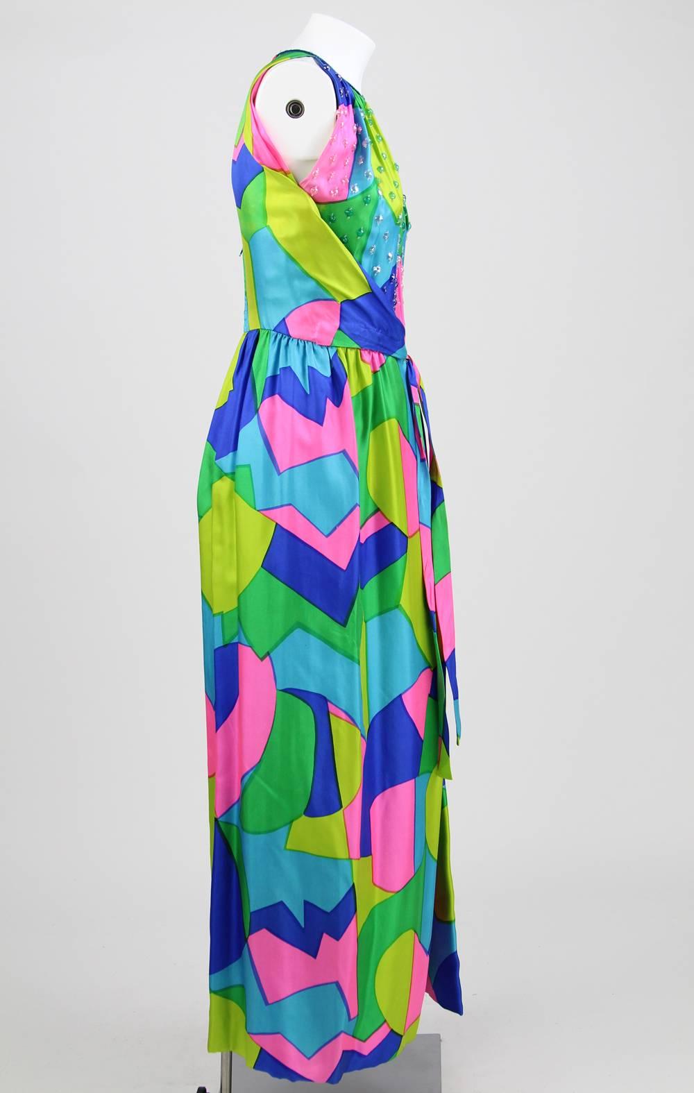 Lively multicolor tailored sleeveless jumpsuit with an abstract pattern. It features wide legs (it looks like a dress), multicolor transparent sequins on the bodice and the collar, and a delicate built-in wrap-around sleeveless cardigan. Fastened by