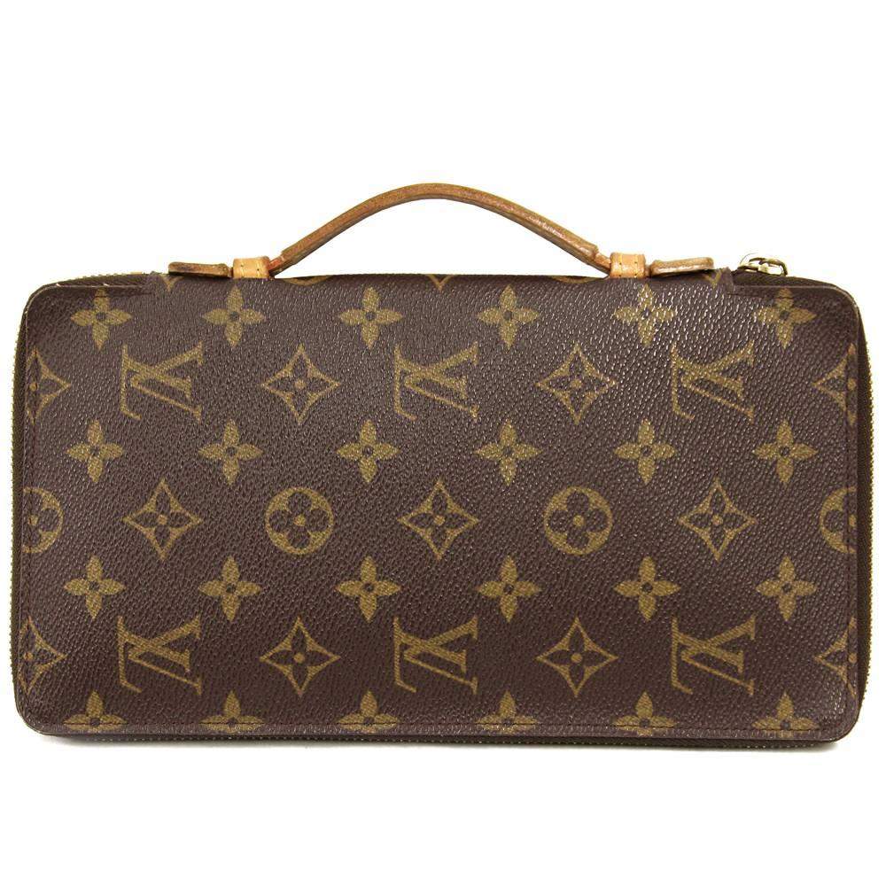 Indispensable Louis Vuitton wallet with the iconic Monogram pattern and leather handle.  Produced on September 1998 (Cod. MI0998). The item is vintage, it shows sign of utilization inside the pockets and on the hardware (see the pictures). It comes