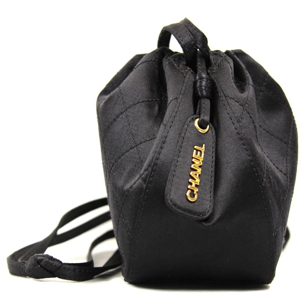 Refined black matelassé silk satin bucket bag by Chanel. According to the code (5773715)  the bag was produced between 1997 and 1999. It has a coulisse fasten which works as shoulder strap. The item is vintage, it's in excellent conditions and shows