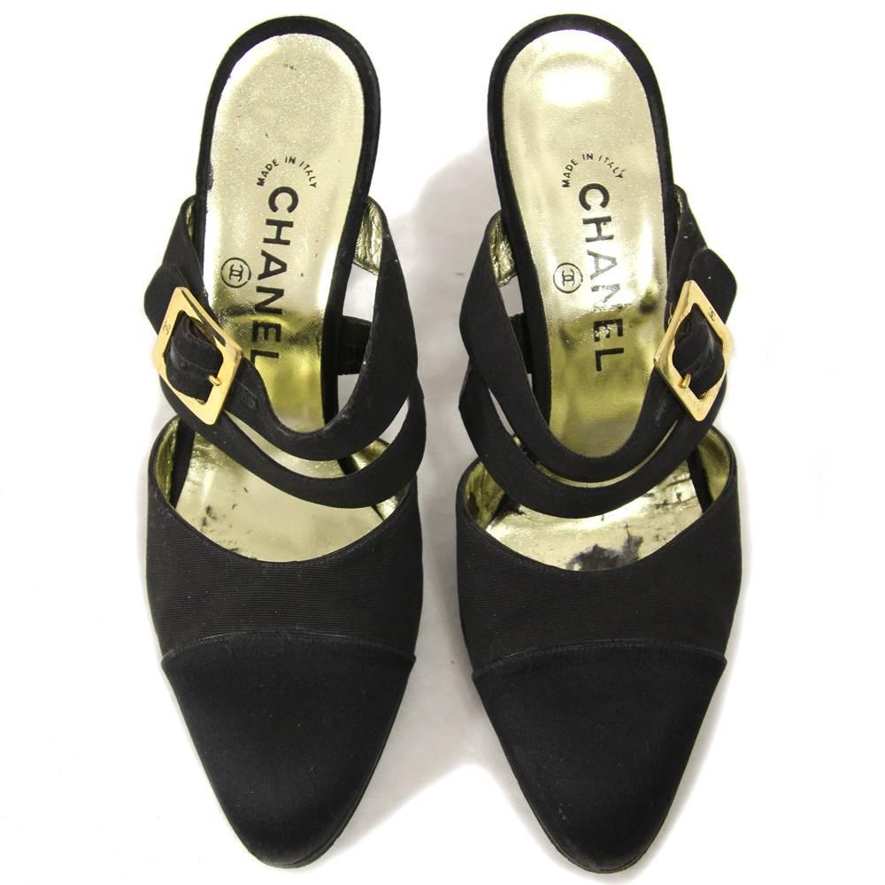 Chanel black silk and leather mid-heeled mules. They feature two straps on the feet and a golden buckle. The item is vintage, is in good conditions but it shows some little signs of utilization (see the pictures). 
Size: 38
Height: 7 cm