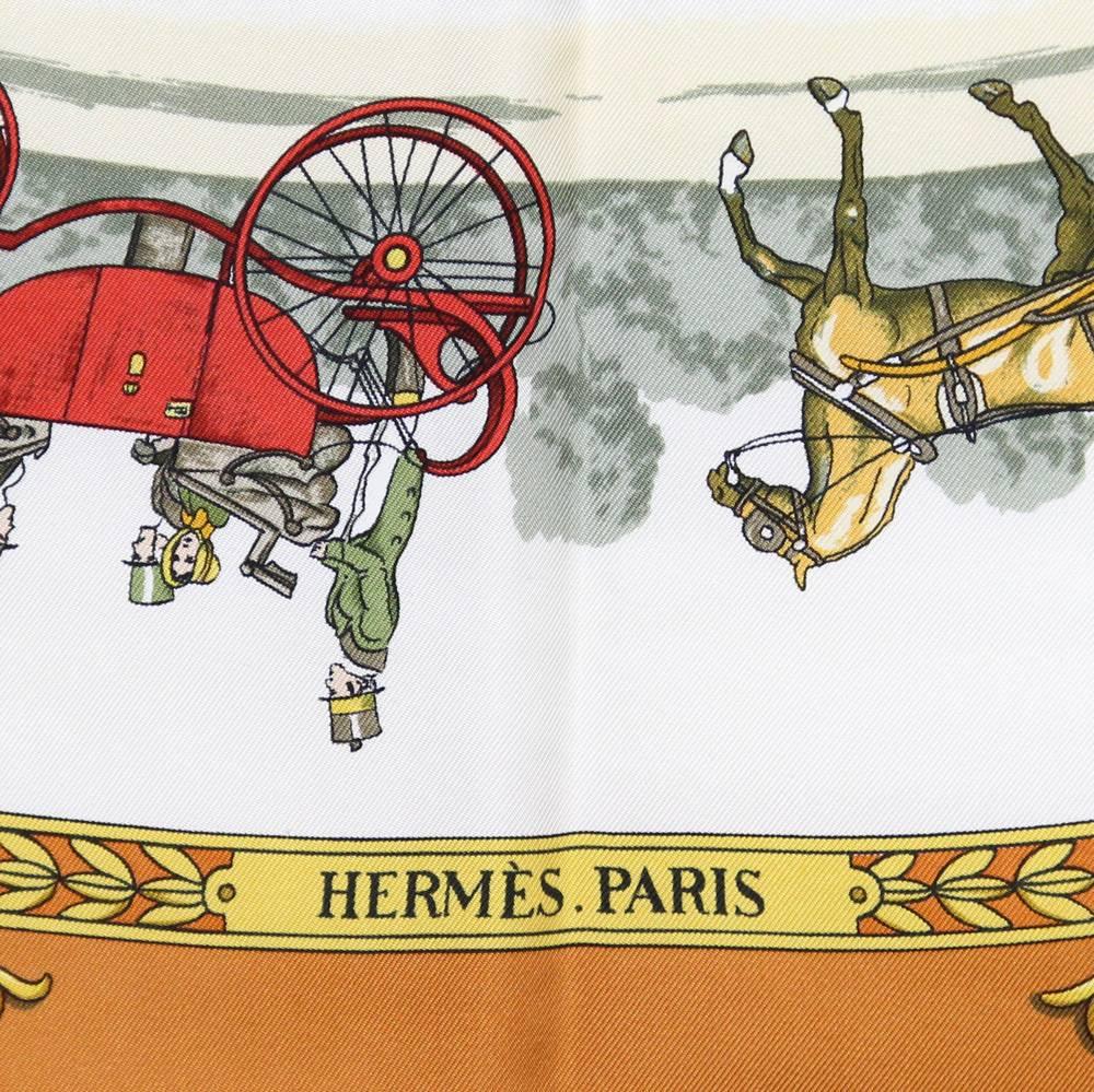 Classic Hermès "La Promenade de Longchamps" 100% slik scarf, designed by Philippe Ledoux. It features women and men on horse and carriages and intricate design of gold horses with vine on the corners. This piece is in very good conditions.