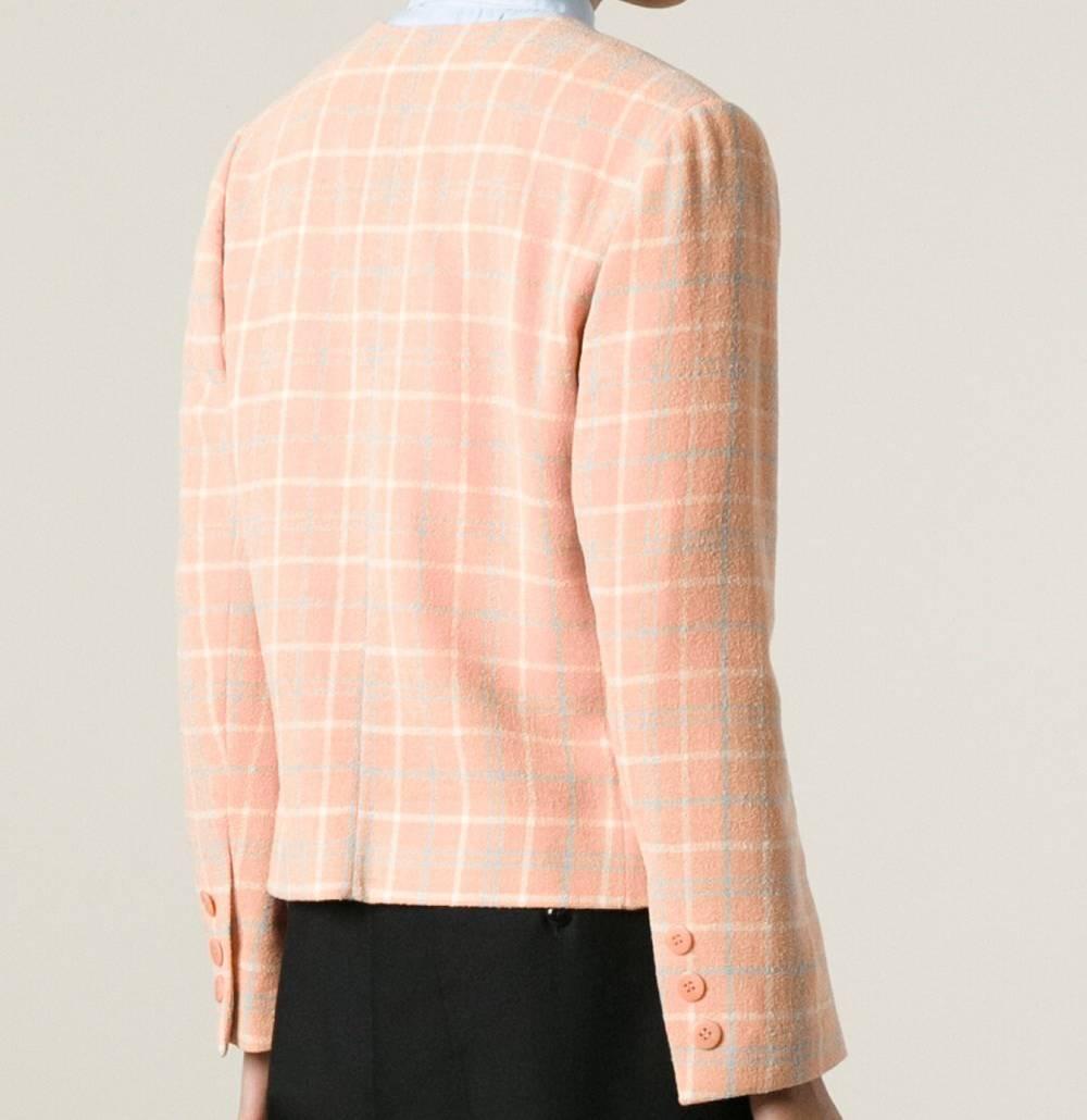 Salmon pink, light blue and white wool and cashmere checked jacket from Céline. It features a v-neck, long sleeves, button cuffs, front flap pockets and a front pink button fastening. The item is vintage, it was produced in the 90s and is in