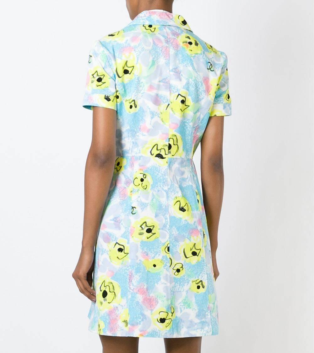 Lively Chanel multicolor printed logo cotton shirt dress in turquoise and yellow. It features a classic collar, decorative big buttons in green and gold, two front pockets, two chest pockets and an embossed 1997 dated logo stamp. The item is