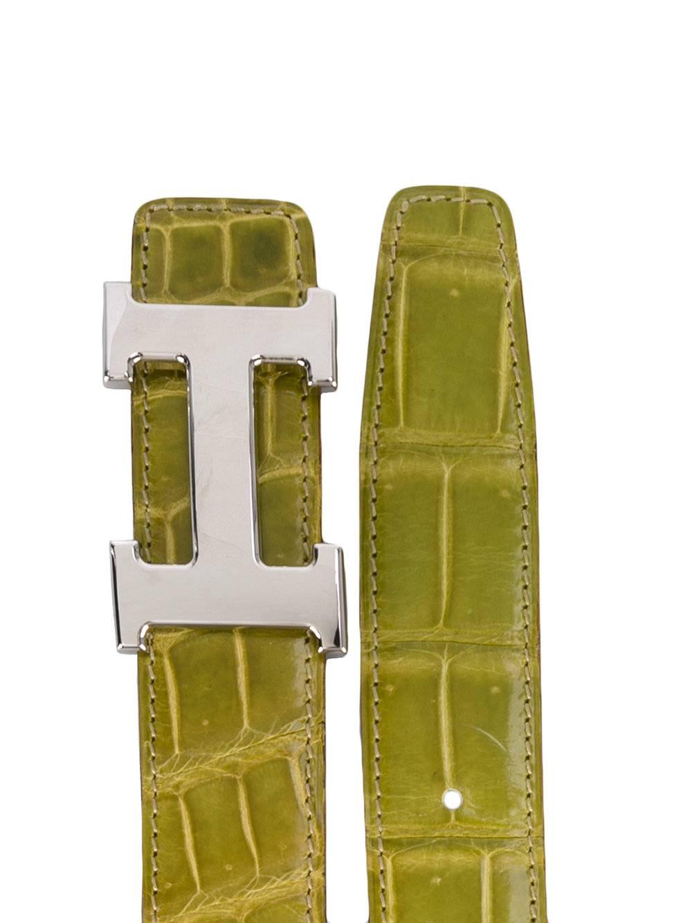 Lively Hermès belt in green crocodile leather and metal. It features punch holes in the green leather, and presenting a broad silver-tone H logo as buckle. This item was made in 2005 and is in excellent conditions, it only shows some light signs of