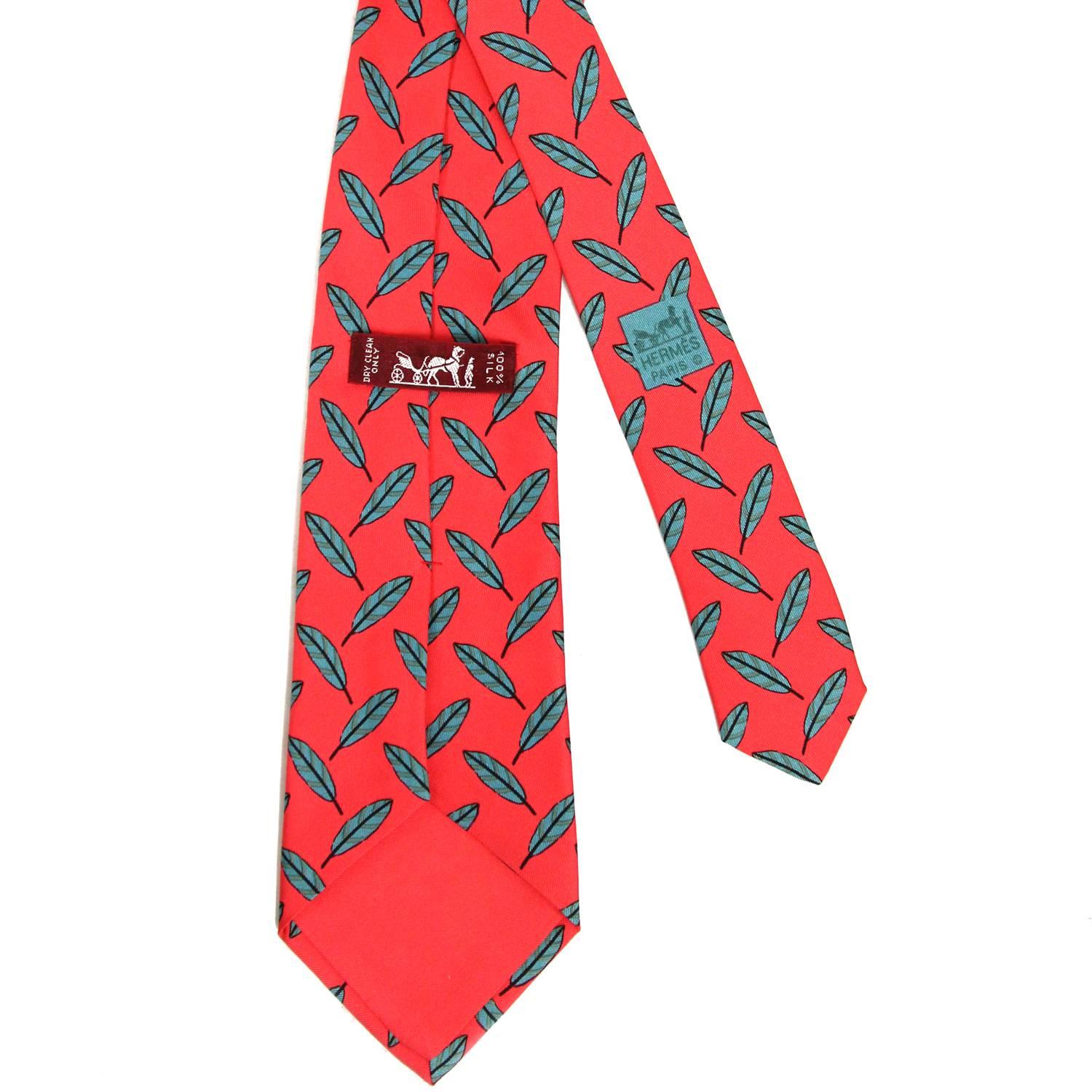 Eye-catching Hermès 100% printed red silk tie with a pattern of green feathers. The item is vintage and is in excellent conditions, flawless.  
Width: 8
