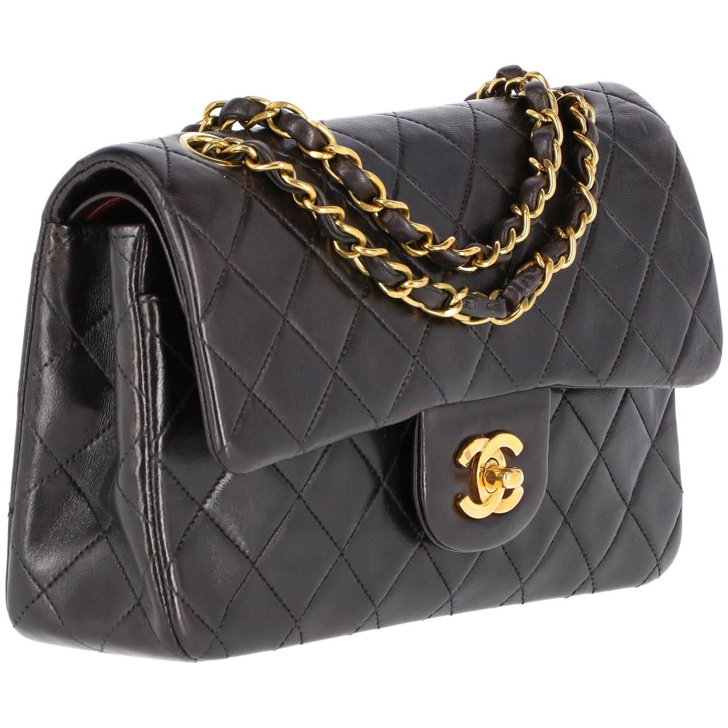 Classic Chanel vintage 2.55 bag made of black quilted leather from the 1990s. 23 cm of width. Features golden hardware in the chain strap with intertwined leather and a burgundy leather inside.
The item shows minor imperfections in the inside of the