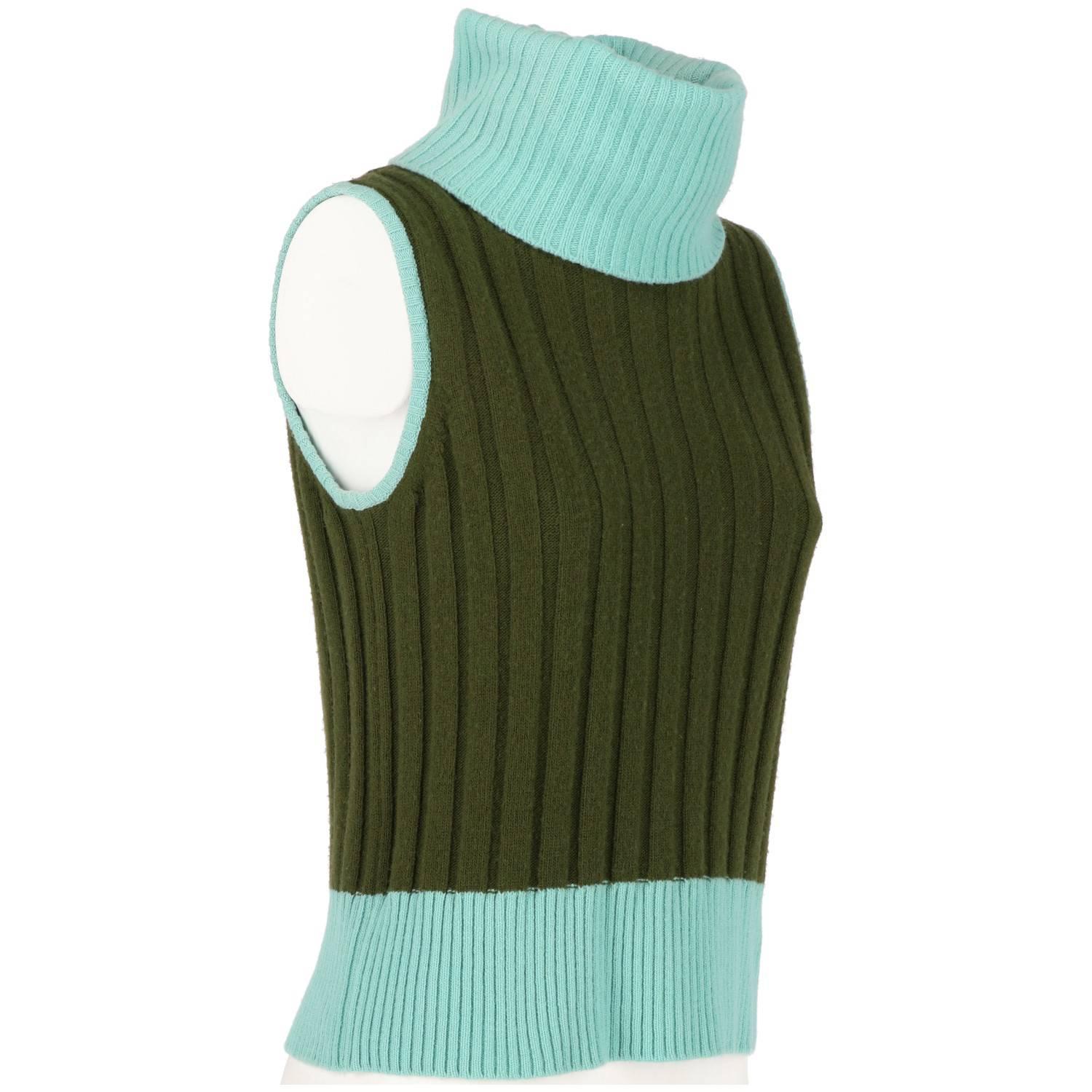 Gianni Versace dark green cashmere and wool sleeveless sweater, with mint green collar and hems. It features ribbed roll neck and a ribbed knit. Button fastening on the back.
The item is vintage, it was produced in the 90s and is in good