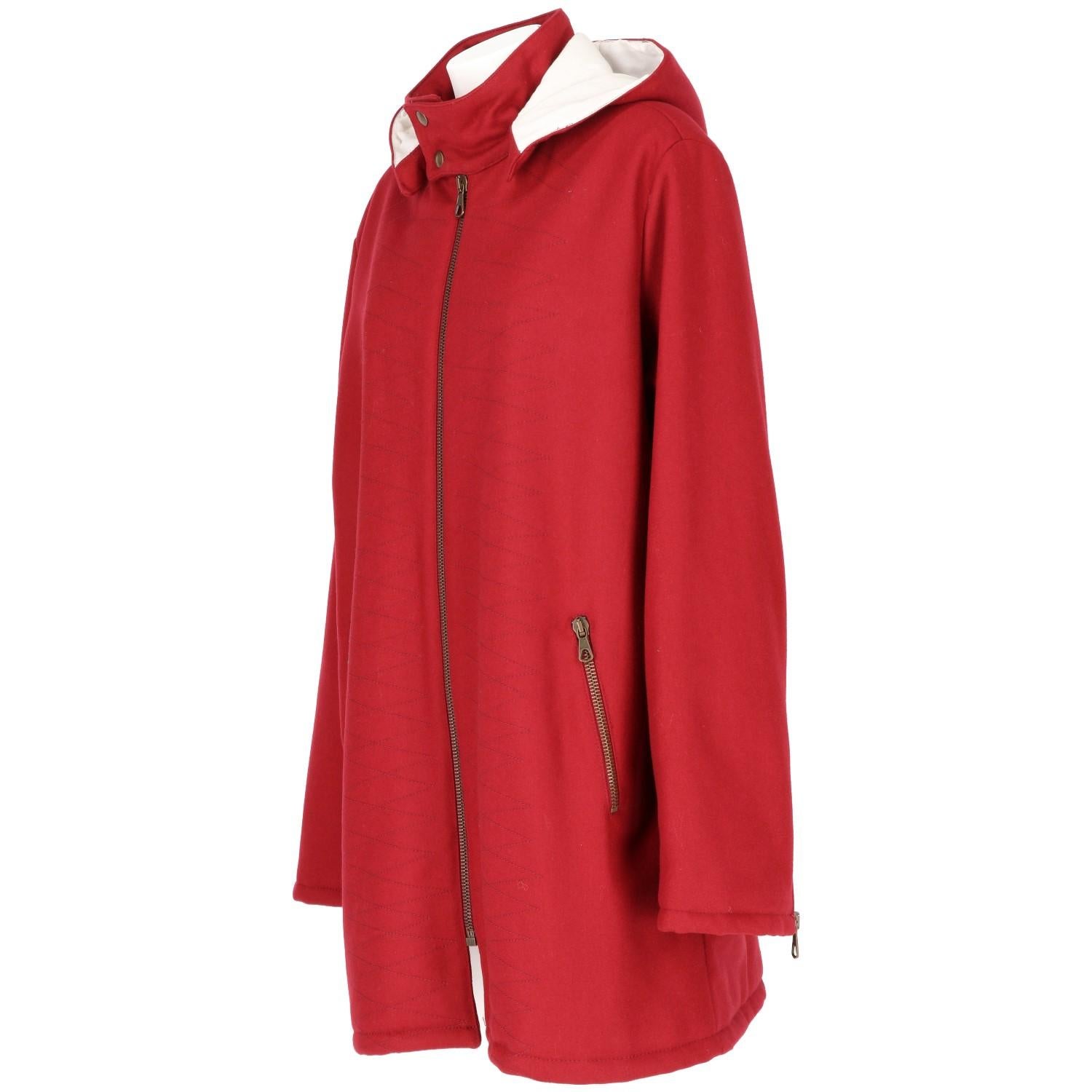 Romeo Gigli cool burgundy cotton and wool blend stitch detail hooded coat. It features a press stud fastening, a front zip fastening, side zipped pockets, dropped shoulders, long sleeves, zip cuffs, a straight hem and a full lining. The item is