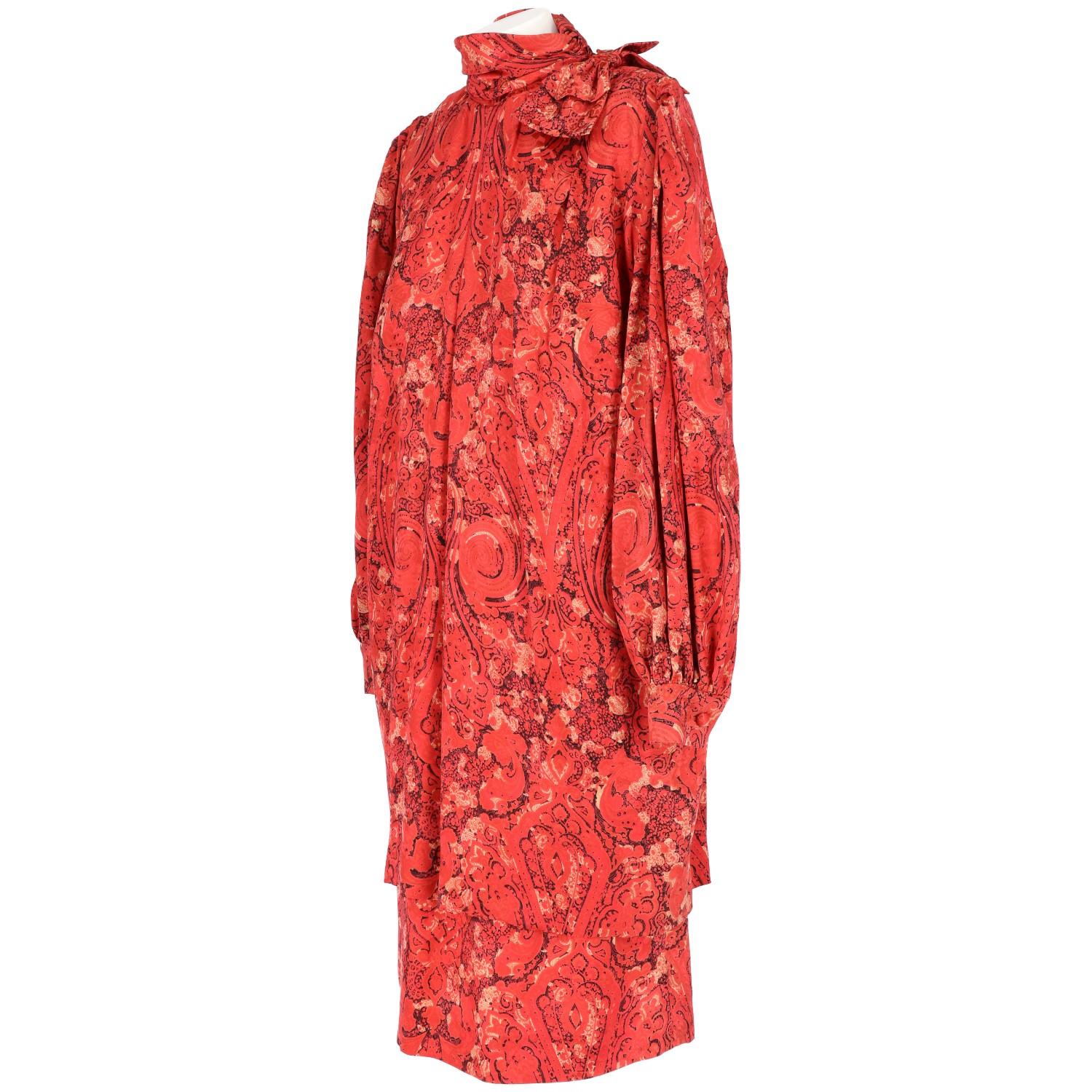 Beautiful Nina Ricci red silk high neck dress. It features a funnel neck with a decorative bow, an all-over print in black and beige colors, ruched detail, loose fit, pleated details, bell sleeves, button cuffs, a mid-length and a rear zip
