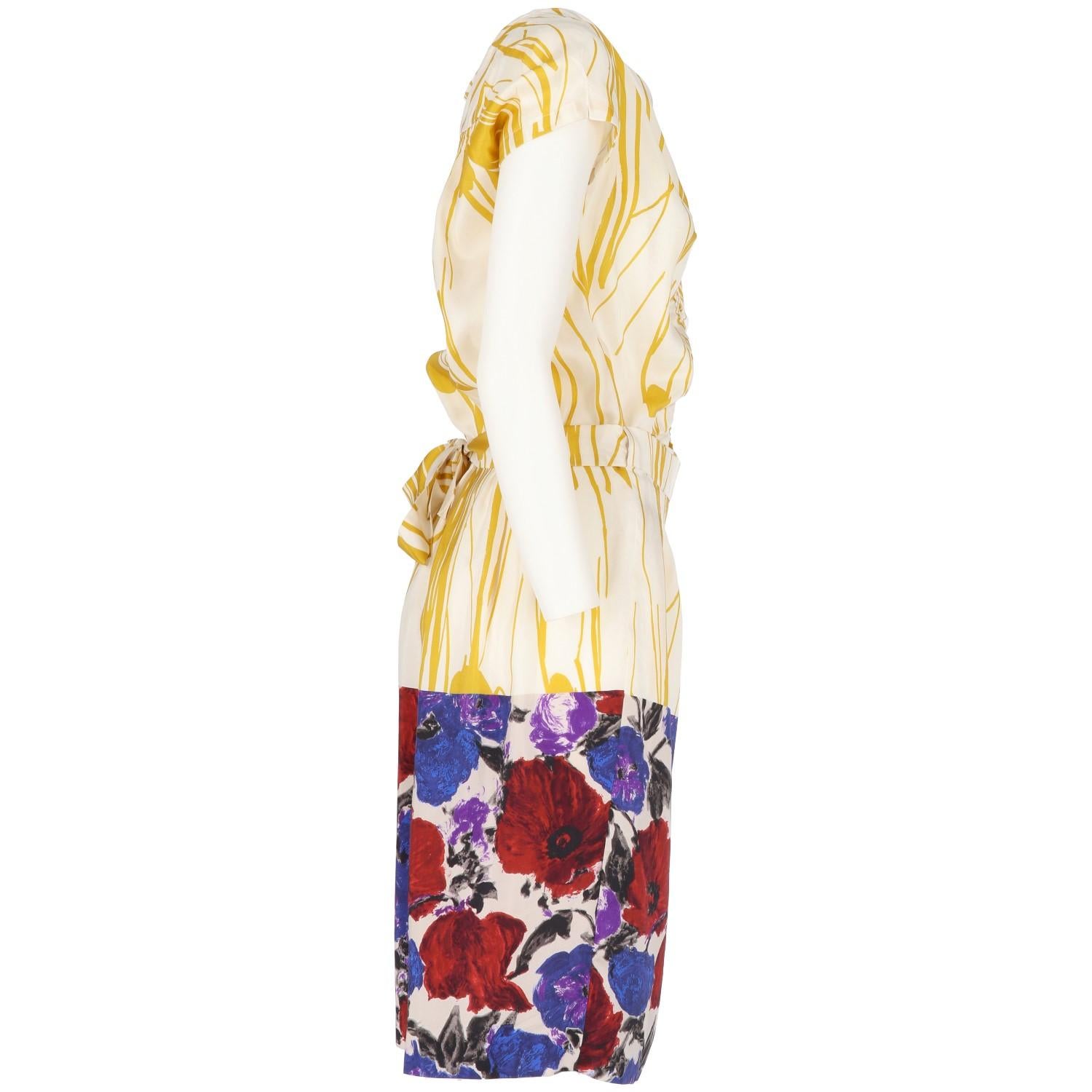 Vivid and fresh Dries Van Noten printed silk short sleeved dress. It features a a mustard yellow pattern and a contrasting floral pattern panel in blue, red, black and purple on the bottom of the belted wrap skirt. V-neckline, gathered fabric on the