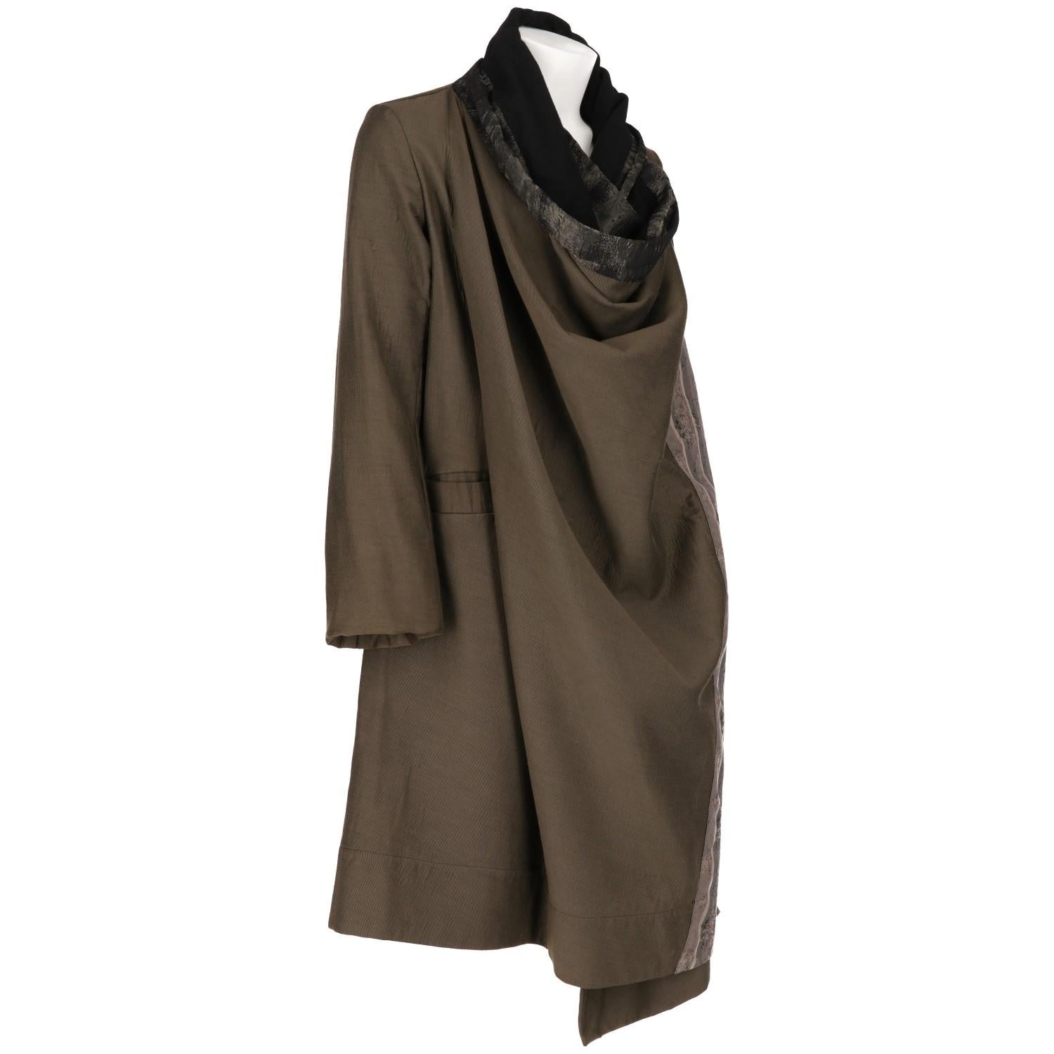 Marvelous Antonio Marras coat in khaki blend cotton fabric with contrasting striped panels. It features an asymmetric and loosing style, and wrap closure with buttons on the shoulders. Two wide welt pockets. Lined in black.

The item is in good