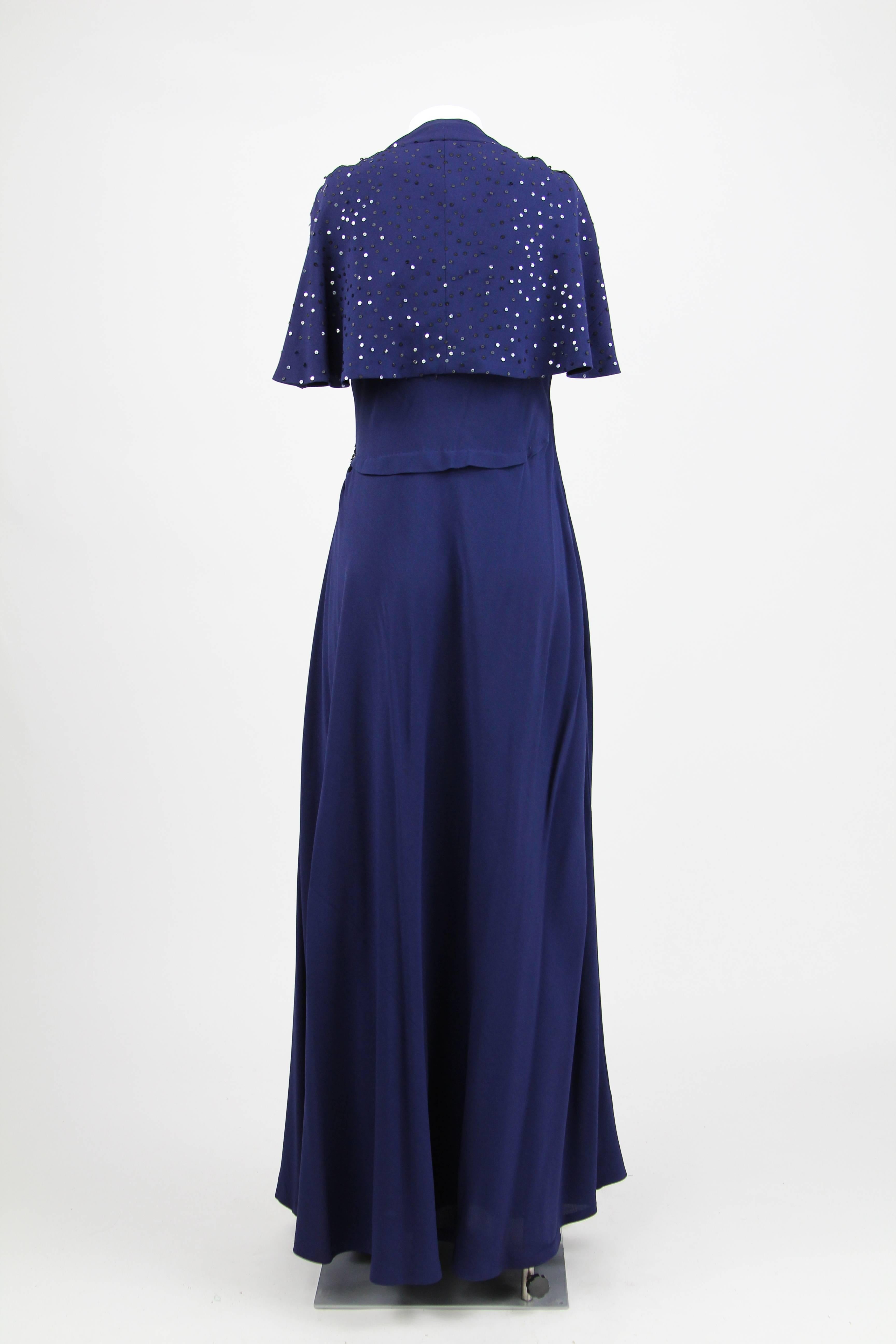 Elegant dark blue draped evening dress, featuring sequin embellishments and a back cut - out covered by an integrated shawl. Carefully handmade in Italy.
Viscose fabric.
Size 40 IT.
This piece is in very good conditions with no signs of wear.
