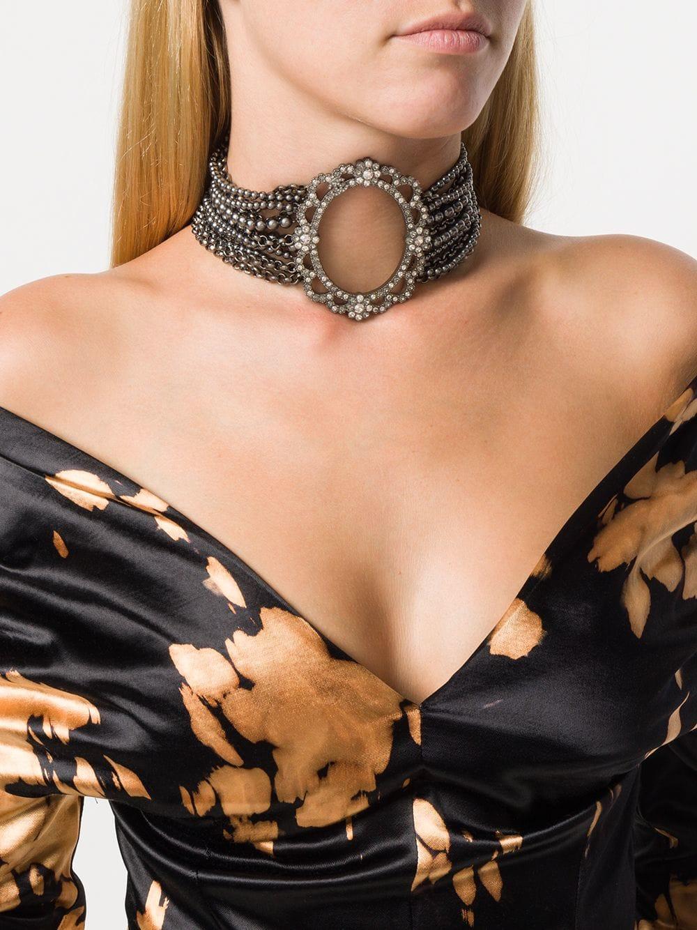 The Chanel silver-tone choker necklace is part of 2015s Chanel collection. With lobster clasp closure and hanging logo details.  Layered beads and silver-tone chains and the crystal oval design embellished on the front, show the elegance of this