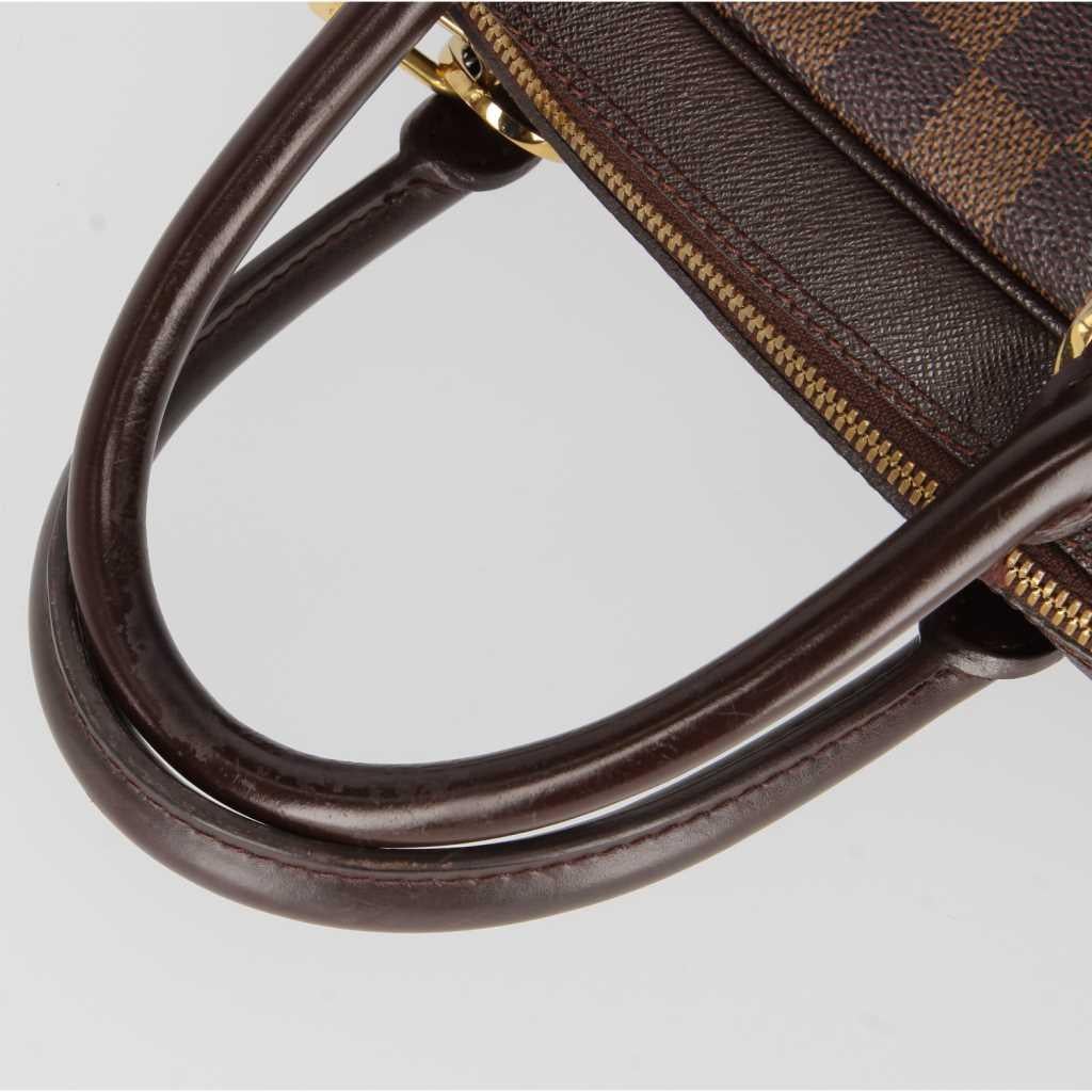 The Louis Vuitton checked and branded with logo canvas bag is made in France, from Autumn/ Winter 2001 Maison Vuitton collection. Handles and the adjustable shoulder strap are in brown leather with metal gold-tone details and zip-fastening. An
