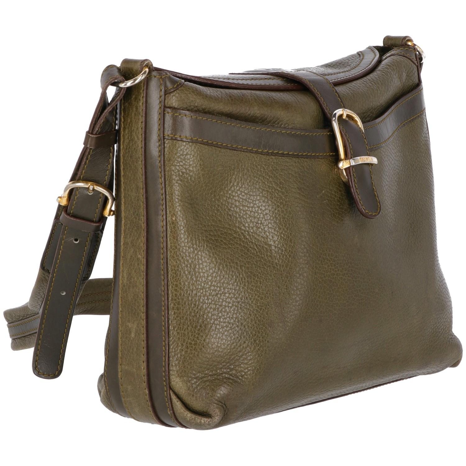 Classic Céline green leather shoulder bag. With gold-tone buckle closure and leather and metal details shoulder strap, it features a brown/bordeaux lining, and two pockets, the welt outer pocket and the inner zip- pocket.  

The item is vintage: it