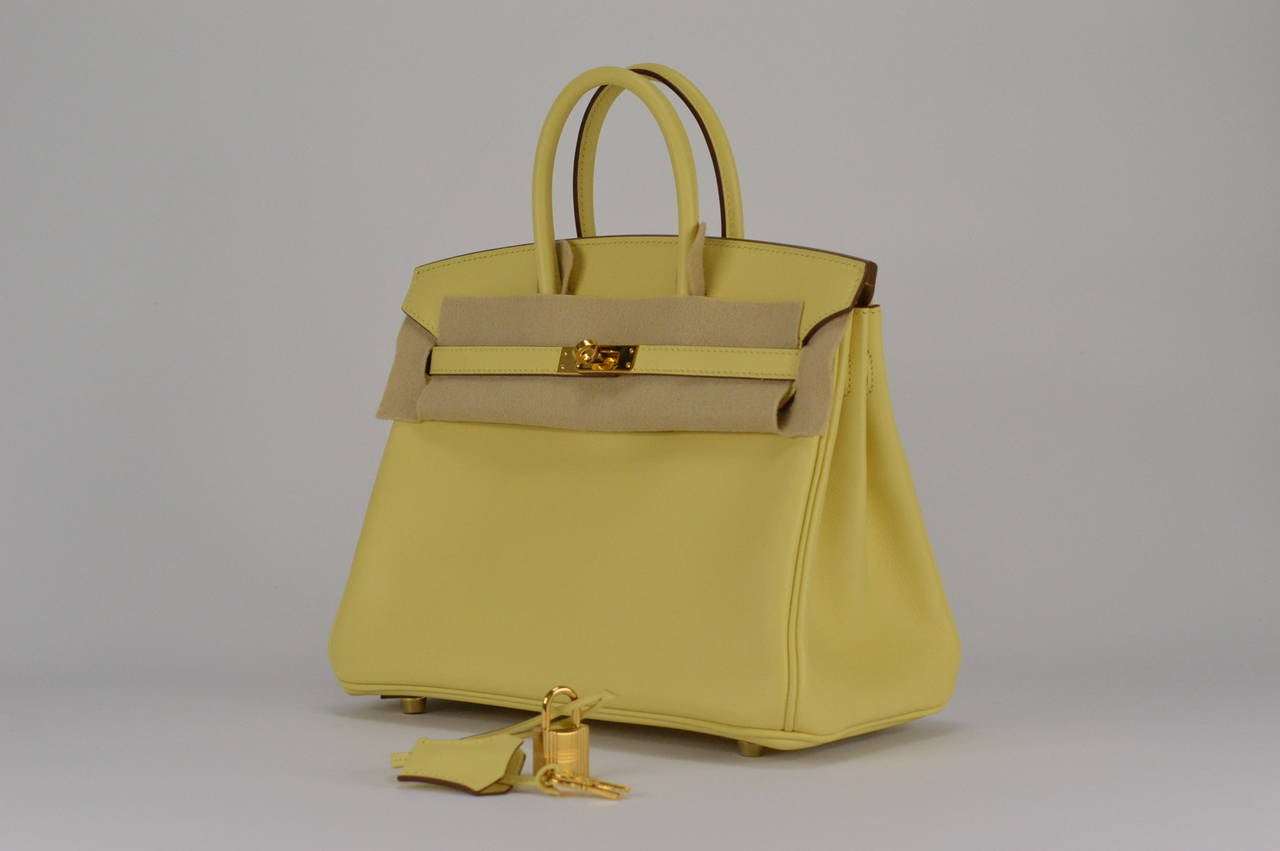 HERMES Handbag BIRKIN 25 SWIFT  JAUNE POUSSIN GOLD HARDWARE
with the protective plastic intact.
Comes with original box, dustbag, clochette, lock, two keys, felt, rain cover, clochette dustbag, and care booklet.
*Protective felt removed for
