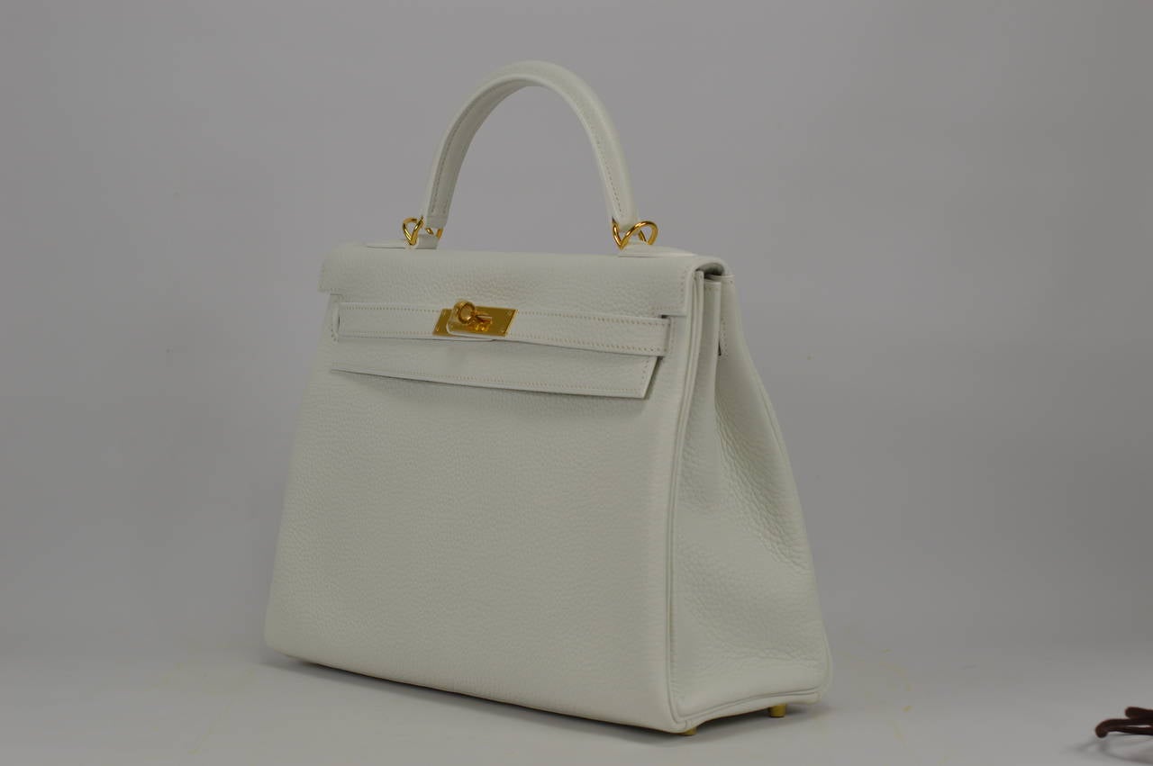 2014 Hermes Kelly Bag  32cm White color Gold Hardware.
Stamp R.
Hardware with protective plastic intact.
Comes with original box, dustbag, clochette, lock, two keys, clochette dustbag, shoulder strap, shoulder strap dustbag, rain cover, felt,
