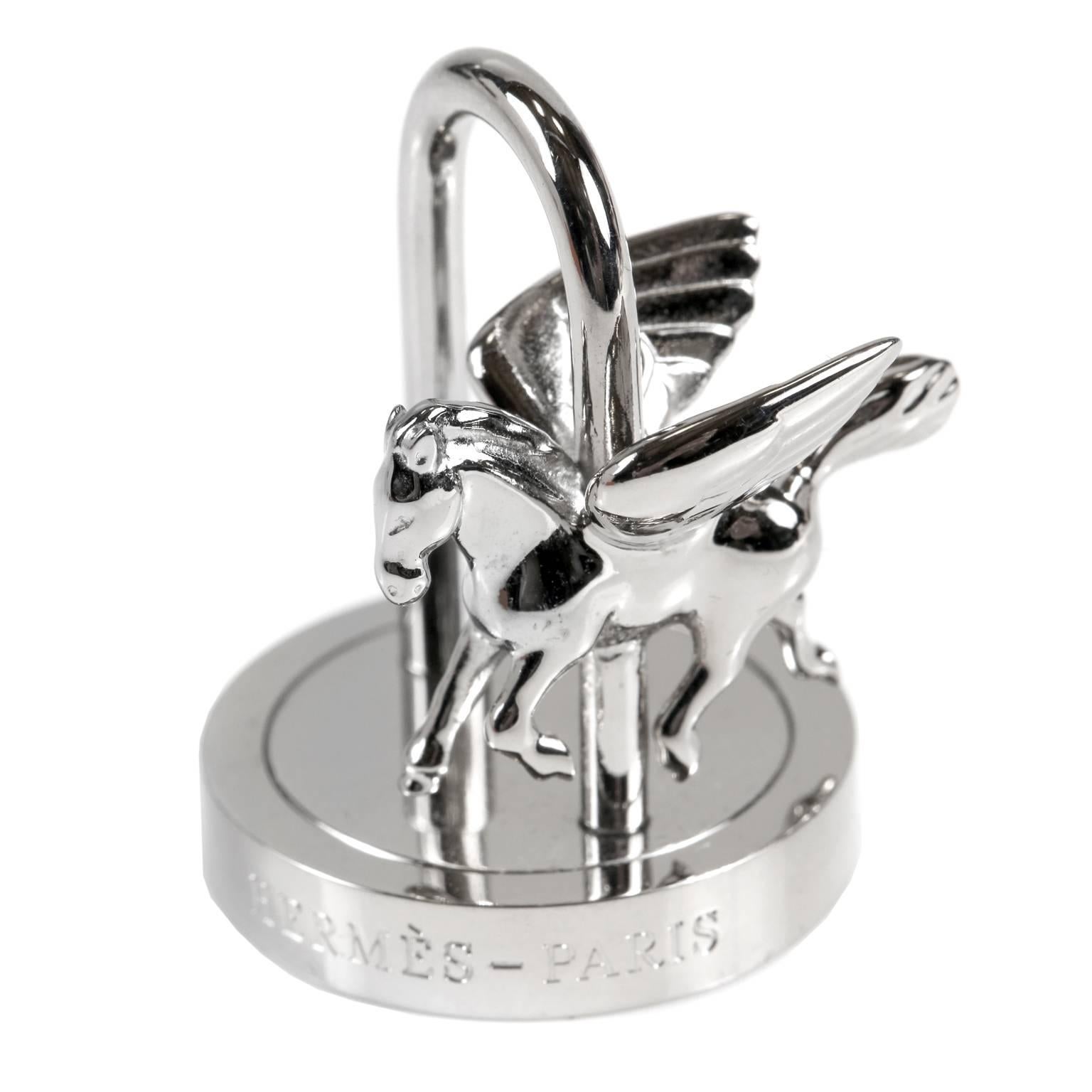 This authentic Hermès Palladium Anee de la Danse Cadena Lock Charm is in mint condition. Palladium Pegasus winged horse on a rotating merry go round base.  Variety of uses include bag charm, necklace pendant or bracelet charm. 
A253