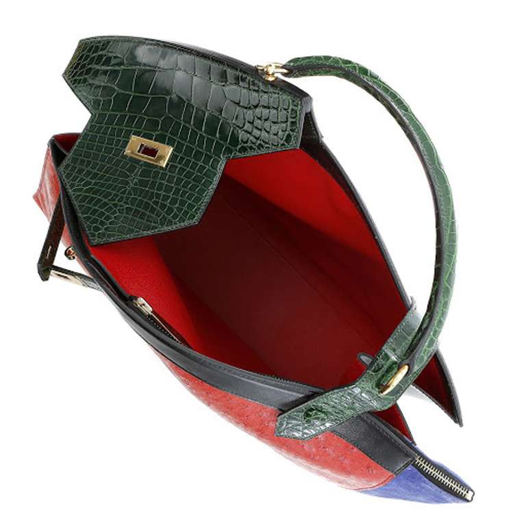 This authentic Hermes Himalayan bag in alligator suede leather is in mint condition and a rare find. The bag has an asymmetrical shape. It uses the colors red, dark green, and blue. The handle can be worn on the shoulder or at the elbow. Made in