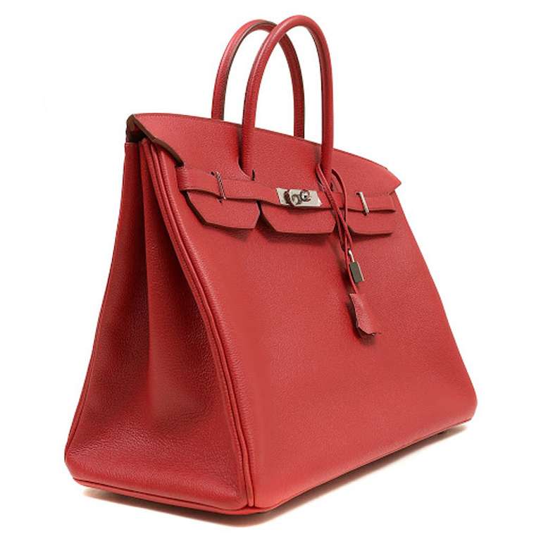 This Authentic Hermès Red Epsom Leather 40 cm Birkin is in pristine unworn condition with the protective plastic still intact on the closure hardware. This Birkin is Red Epsom leather with Palladium hardware; a striking combination with timeless
