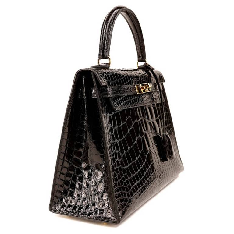 This Authentic Hermès 25 cm Black Alligator Kelly is in mint condition. The streamlined and demure Kelly style is always in high demand; it is particularly rare in this coveted exotic with gold hardware. Alligator is one of the most prestigious