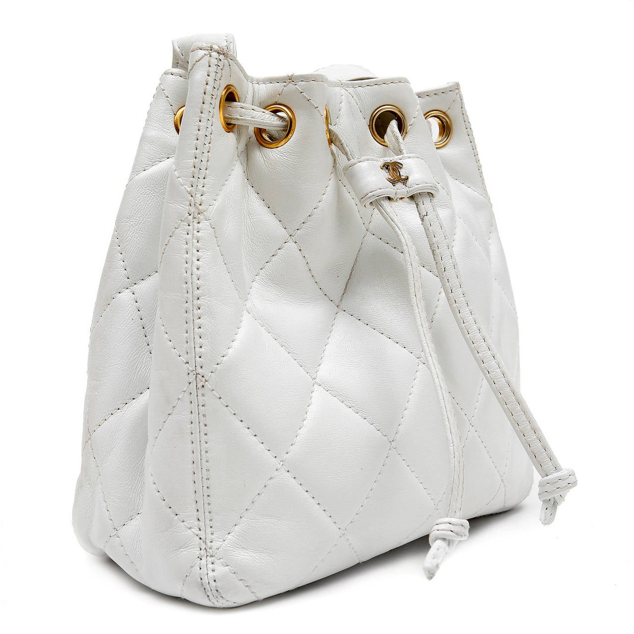 Chanel White Lambskin Drawstring Bucket Bag- Excellent Plus
Petite in stature, the classic bucket style is perfect for traveling with just the essentials. 
 
White lambskin is quilted in signature Chanel diamond stitched pattern.  Leather draw