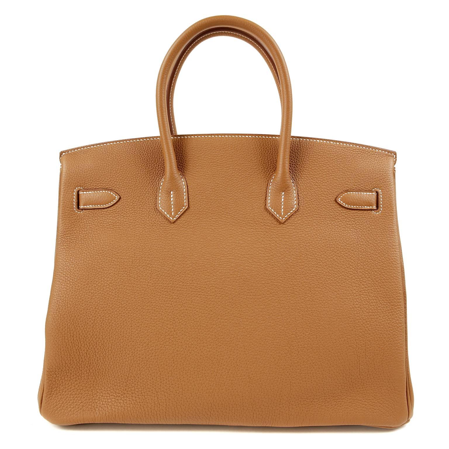 Hermès 35 cm Gold Birkin Bag in Togo leather with Palladium hardware, T stamp.  Pristine unworn condition.  Plastic is intact on all hardware.
 
Waitlists exceeding a year are commonplace for the intensely coveted classic Gold leather Birkin bag.