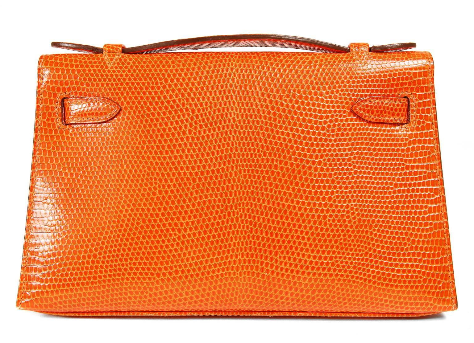 Hermès Orange Lizard Kelly Pochette-  PRISTINE
Hand crafted by skilled artisans, this collectible Hermès is especially rare in exotic lizard skin. 
 
Orange lizard skin is a brilliant pop of color that displays the texture of this exotic