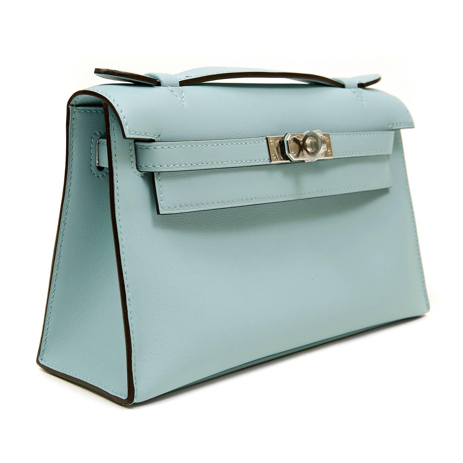 Hermès Blue Atoll Swift Kelly Pochette is in pristine condition; never before carried with the protective plastic intact on the hardware.   Hand crafted by skilled artisans, the Kelly Pochette is highly coveted and favored by celebrities like