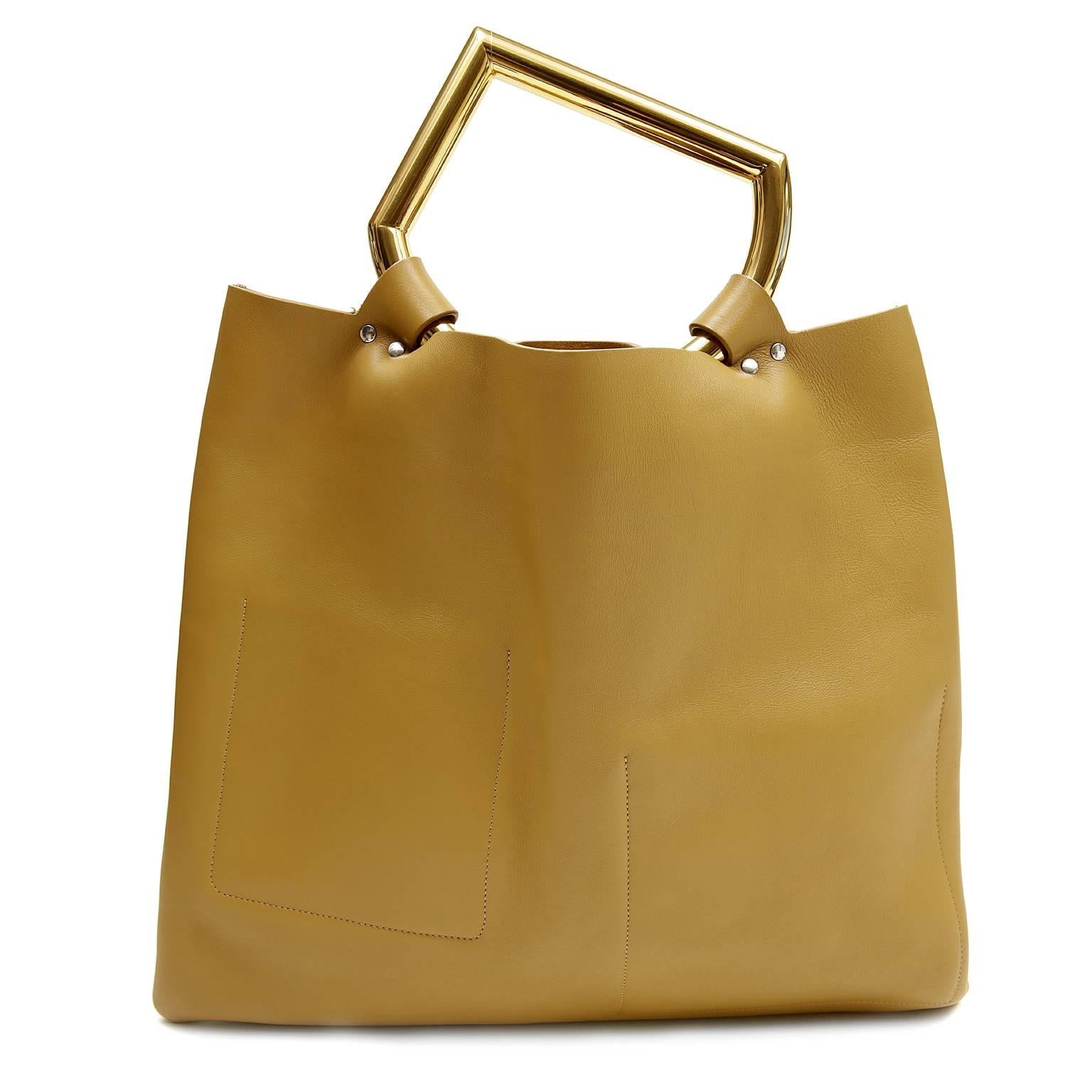 Celine Geometric Handle Runway Tote-  Pristine 
 The striking patch pocket design is neutral with a slim silhouette; perfect for every day year round enjoyment. 
 
Neutral dark goldenrod (a  golden beige color) calfskin has three exterior patch