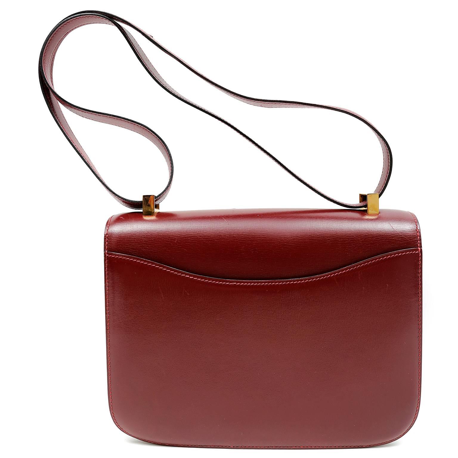 Hermès Burgundy Box Calf 23 cm Constance is in beautiful condition, nearly pristine. One of Jackie O’s favorite Hermès styles, she was often photographed wearing one of the many Constance bags in her collection. Highly sought after, the Constance
