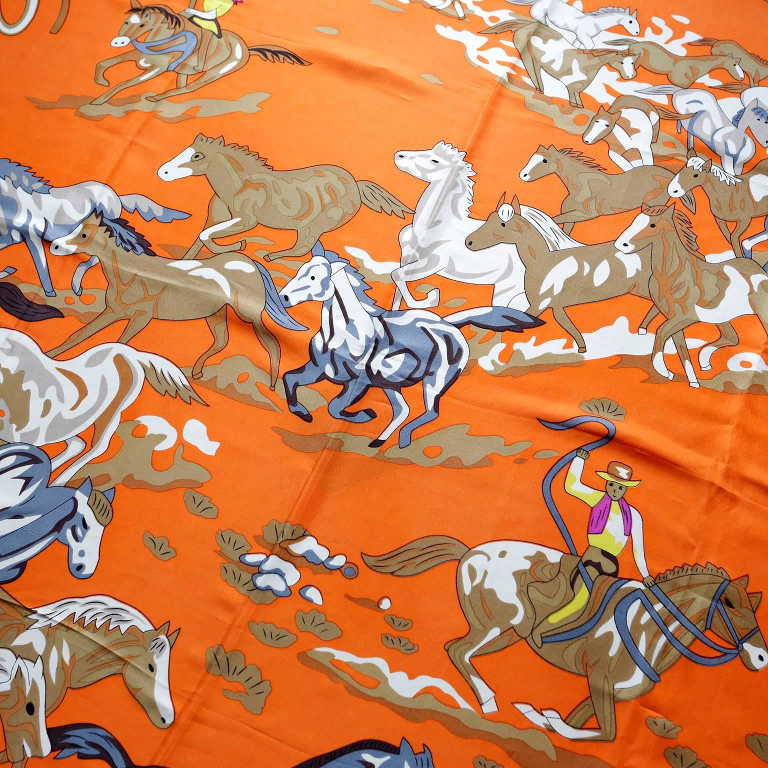 Hermès Orange Seide Les Mustangs Riesenschal- PRISTINE, Sammlerstück
Der ursprünglich von Robert Dallet entworfene Schal in leuchtenden Farben zeigt Bilder von Cowboys, die eine Herde wilder Mustangs zusammentreiben.  
Oranger Hintergrund mit