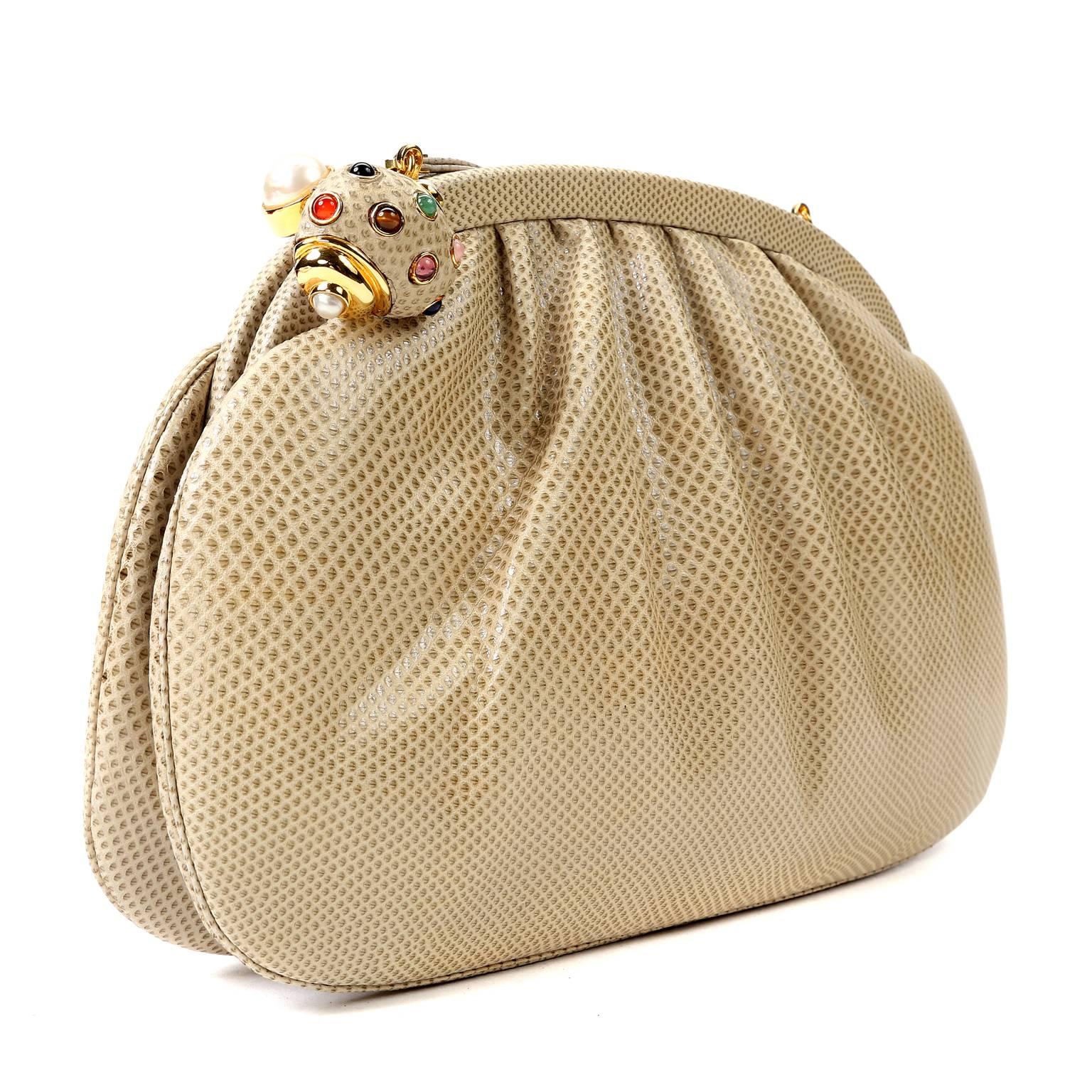 Judith Leiber Beige Lizard Evening Bag- EXCELLENT PLUS
The medium sized silhouette is conveniently sized for those who like to carry a bit more than a lipstick.
 
Beige lizard skin clutch is framed at the top with a bejeweled snail clasp sitting