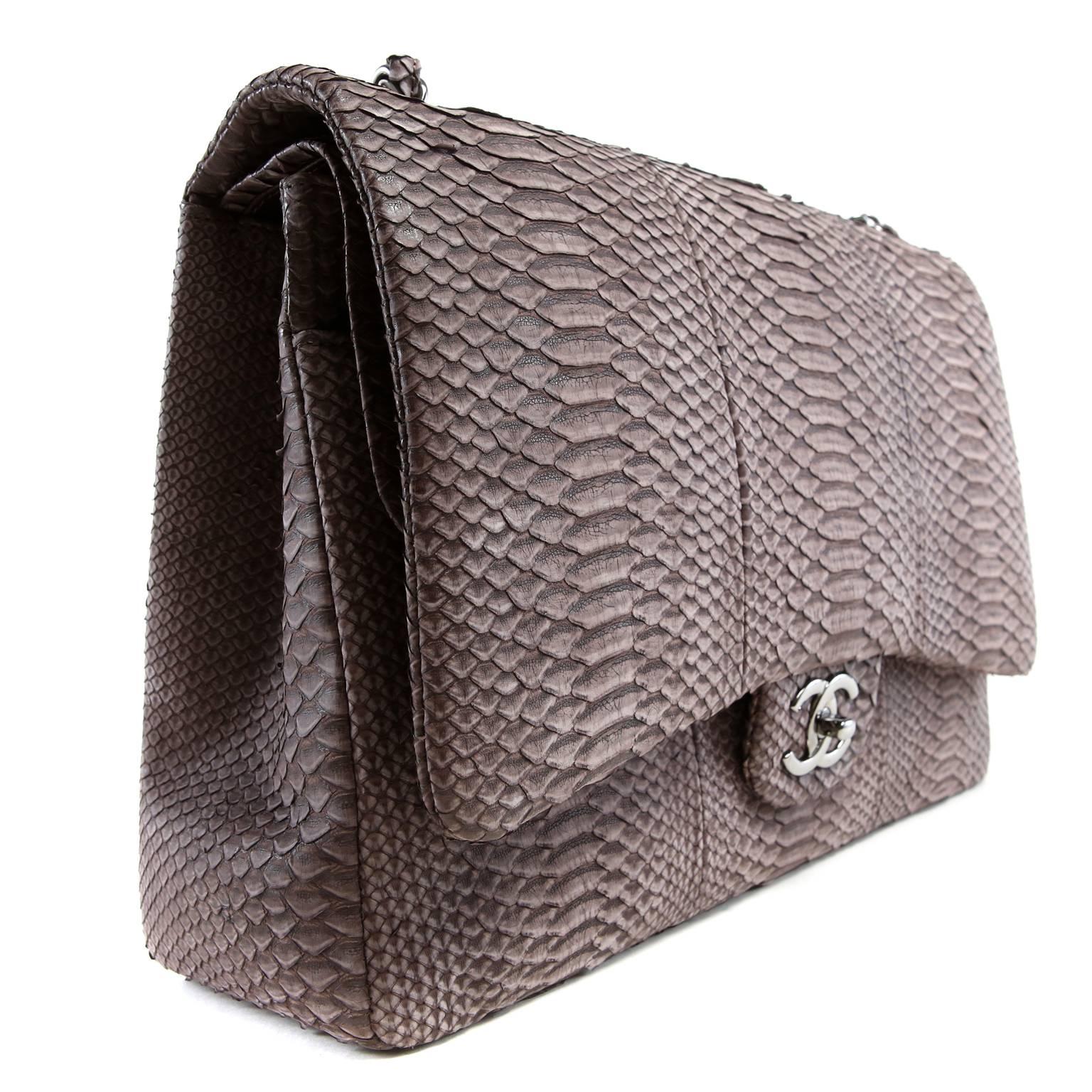 Chanel Taupe Python Jumbo Classic is in pristine condition.  The rare style has a sueded finish softening the façade of this rich exotic. 
Taupe python has a soft muted finish.  Silver interlocking cc twist lock secures the exterior flap.  Simple