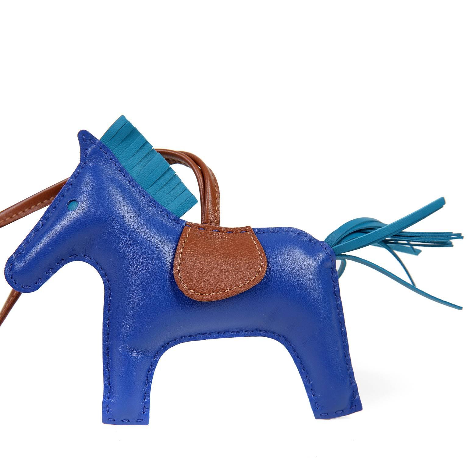 Hermès Bleu Electrique Lambskin Milo Rodeo MM Horse Charm is new. The perfect addition to any bag, this whimsical charm is very collectible as well. 

Blue Electrique lambskin stuffed horse has fringed Blue Jean mane and tail.  Classic gold
