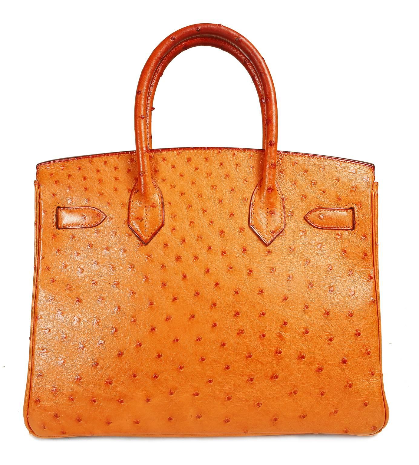 Hermès Orange Ostrich 30 cm Birkin is in pristine condition.  Hermès bags are considered the ultimate luxury item the world over.  Hand stitched by skilled craftsmen, wait lists of a year or more are commonplace.  This particular Birkin is in