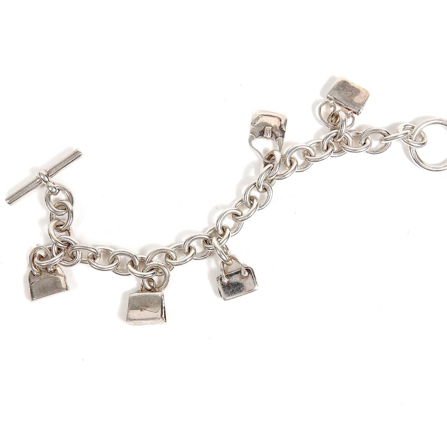 Hermès Sterling Silver Charm Bracelet- PRISTINE
  Adorned with five iconic Hermès bag charms, this is a wonderful piece for any collection. 

Silver link chain with toggle closure.  Five iconic bag charms include a Constance, Kelly, Plume, Trim and