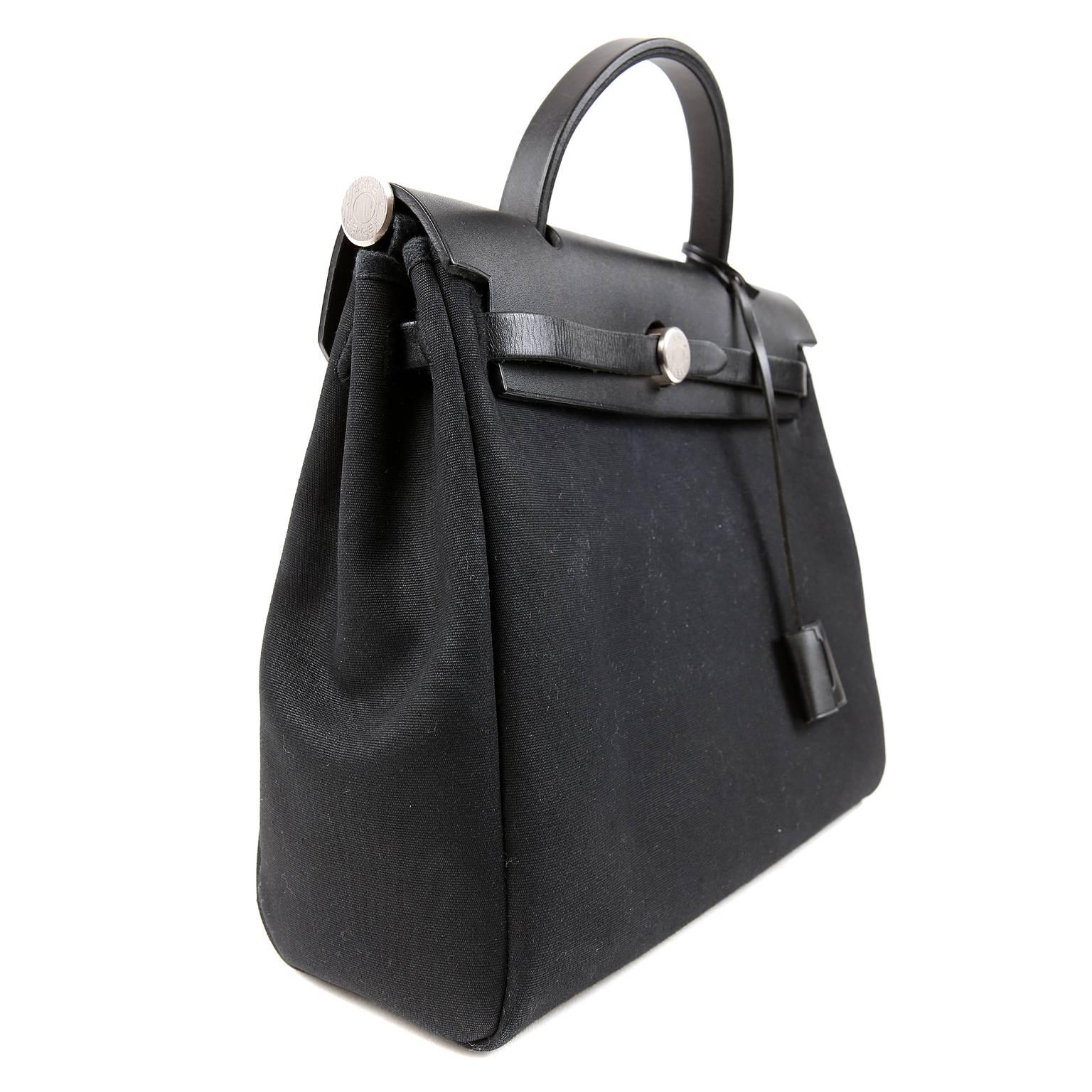 Hermès Black Her Bag- Pristine   Condition, appearing never carried
The Her Bag is comprised of toile fabric with a rigid leather top.  It has a similar look to the Kelly but with a far less demanding price tag.  Best of all, the Her comes with an