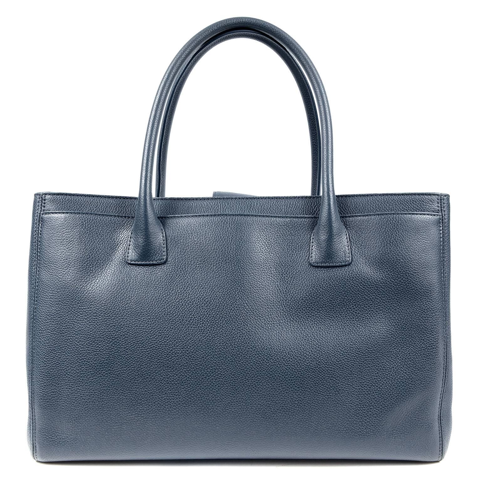 Chanel Navy Leather Cerf Tote- Pristine Condition
The classic style is equally popular for professional or casual daily use. 

Grained navy blue leather tote has a silver interlocking CC twist lock securing a spacious front pocket.  A magnetic snap