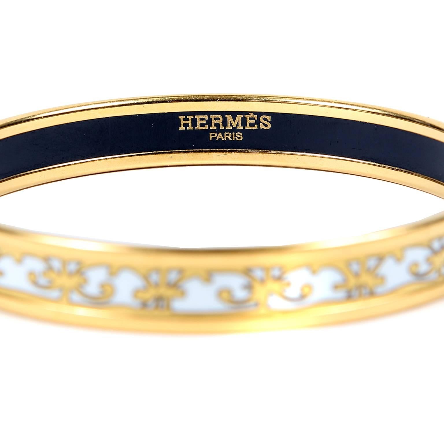 Hermès White Enamel Thin Bangle Bracelet is in excellent condition.  Feminine scrolled pattern in white and gold enamel with gold hardware. Made in France.
A099