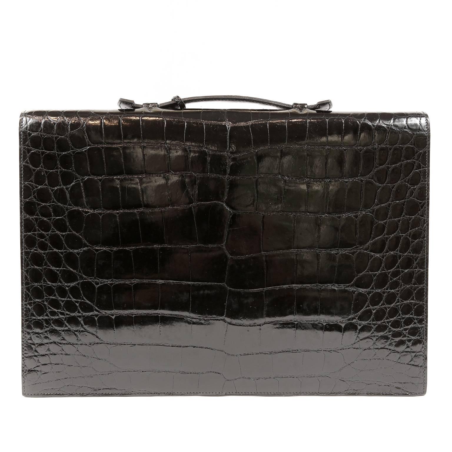 This authentic Hermès Black Porosus Crocodile Briefcase is in MINT condition. Everything about this piece exudes exquisite taste and opulence.  
Shiny black crocodile skin slim briefcase with gold hardware clasp.  Single top handle.  Black leather