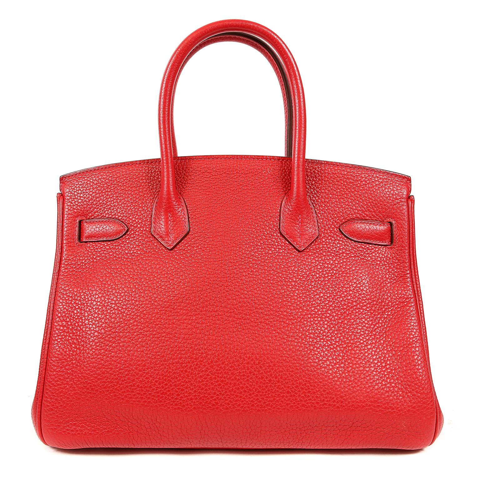 This authentic Hermès Rouge H Togo 30 cm Birkin is pristine. Hand stitched by skilled craftsmen, wait lists of a year or more are not uncommon for the Hermès Birkin. They are considered the ultimate in luxury fashion. Rouge H is a highly desirable