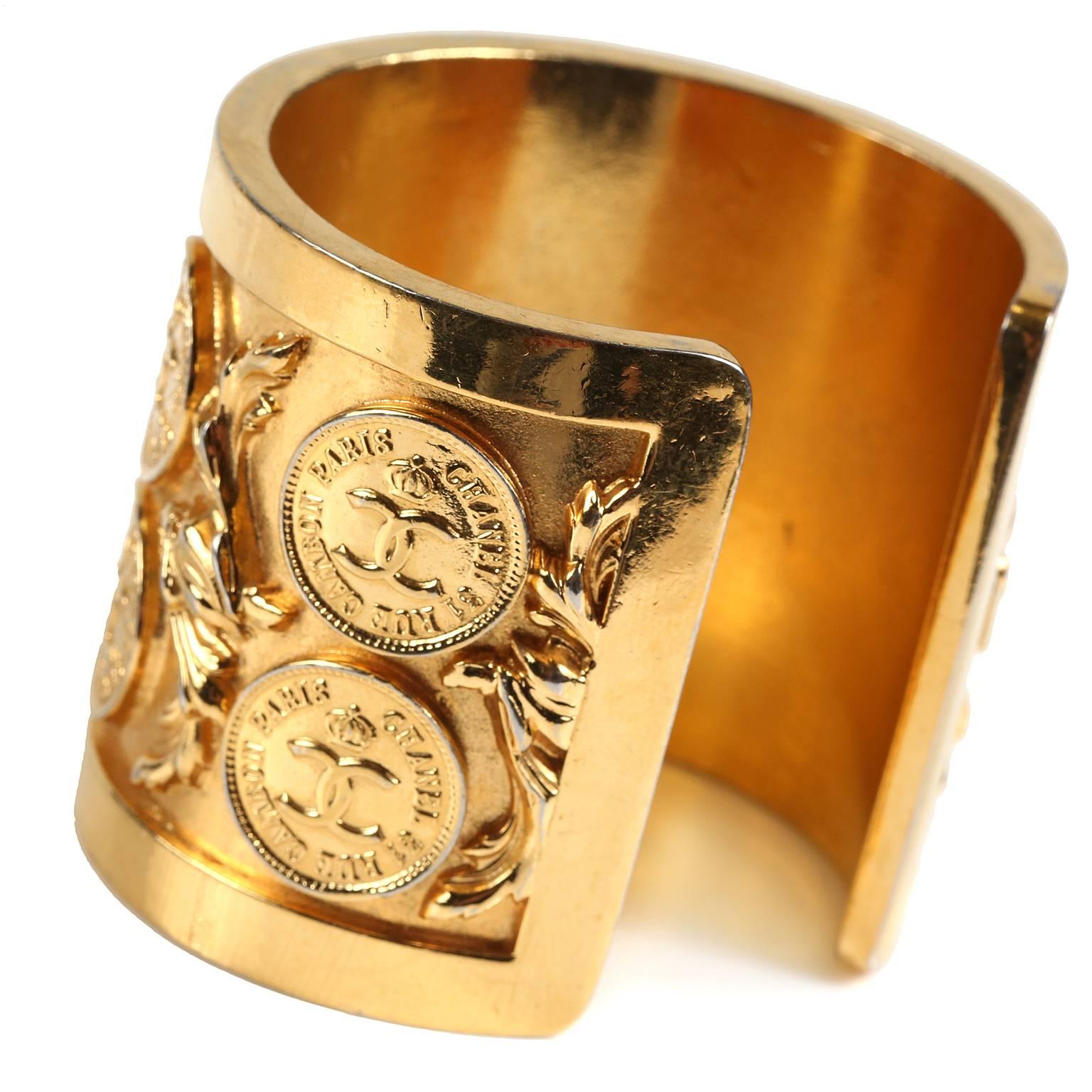 This authentic Chanel Vintage Gold Coin Cuff is in excellent plus condition.  A remarkably striking piece from the 1980’s, it is a must have for collectors.  
Wide gold tone cuff features intricately detailed interlocking CC coins and scrolling