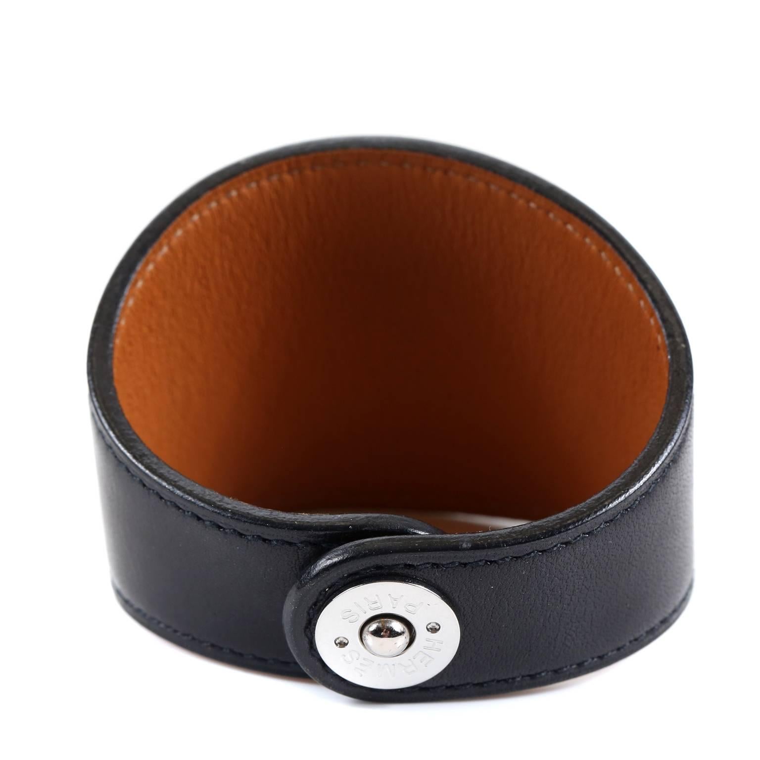 This authentic Hermès Black Leather Ex Libris Cuff Bracelet is pristine.  The simple design can be worn with anything year-round and is equally suitable for both men and women.  Black leather wide cuff has stamped imprint of Ex Libris design- iconic