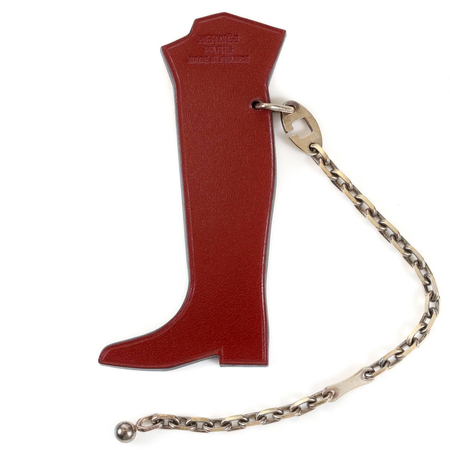 Hermès Hotte Botte Leather Keychain- MINT condition with the original box
  Burgundy veau box equestrian boot is stuffed with colorful gifts.  Silver tone chain attaches to a bag or keys. Rare, iconic and collectible. Made in France.
A197
