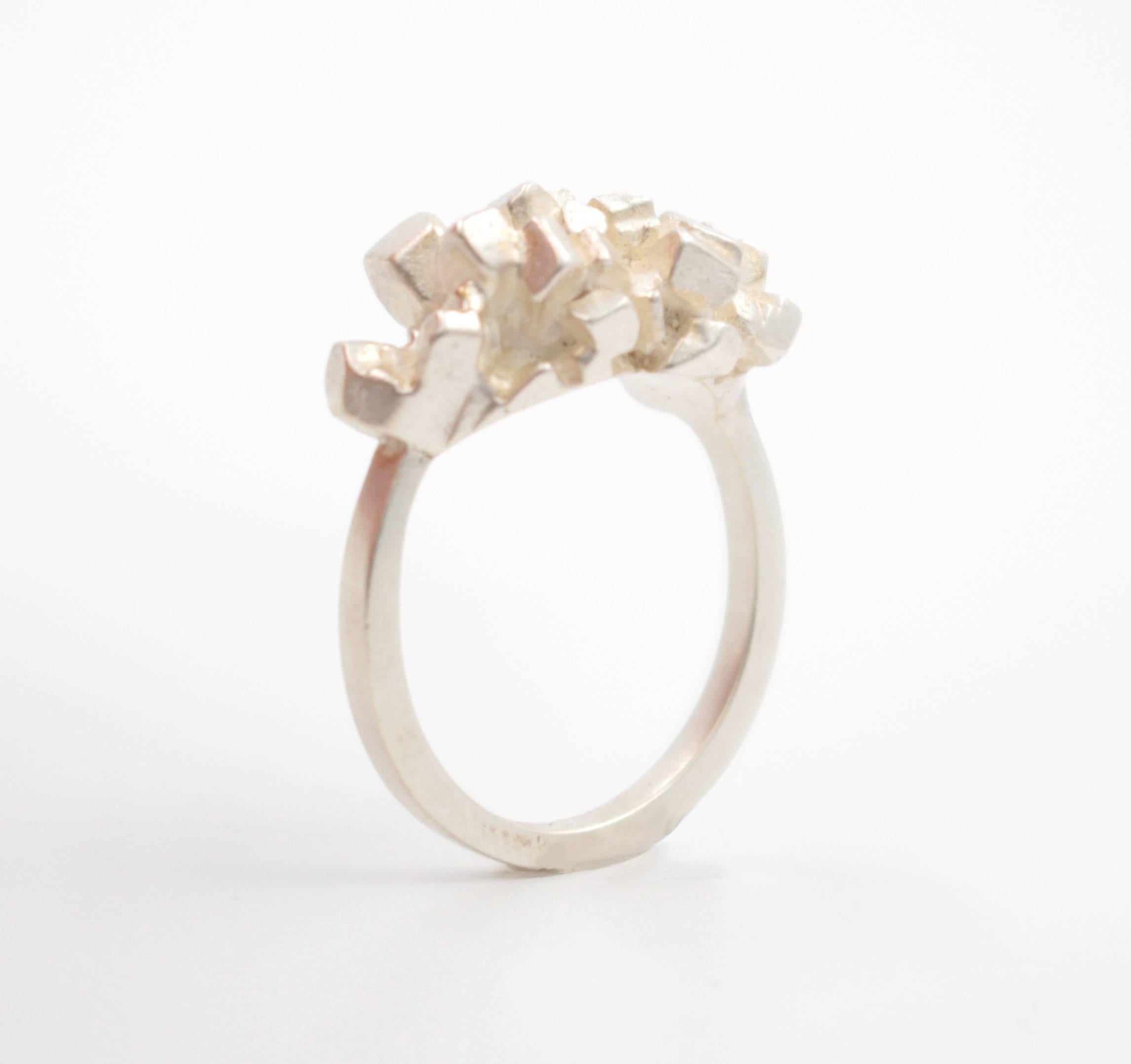 The Sweet Chunk Ring is a satin finished sterling silver ring with cluster of cubic shapes over the top of the ring. Size 7, can be sized to fit.