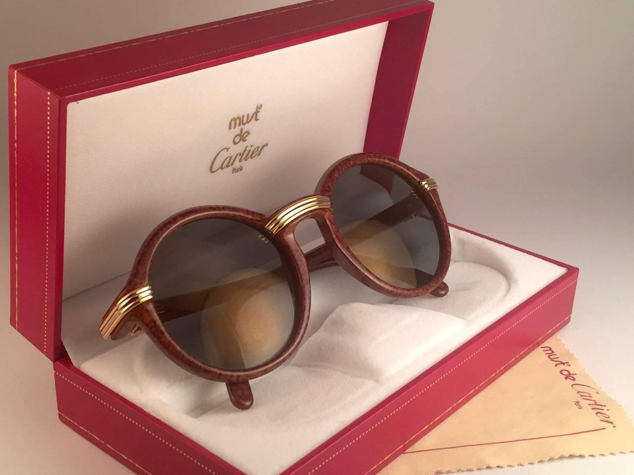 New 1991 Original Cartier Cabriolet Art Deco sunglasses with slight gold mirror ( uv protection ) lenses.
Frame has the famous real gold and white gold accents in the middle and on the sides. 
All hallmarks. Cartier gold signs on the earpaddles.