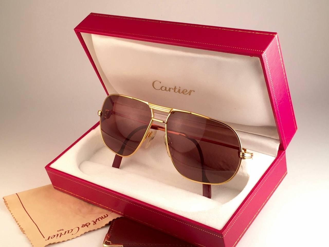 New 1988 Cartier Aviator Tank sunglasses with new honey brown (uv protection)
Frame is with the front and sides in yellow and white gold. 
All hallmarks. rRd enamel with cartier gold signs on the earpaddles. so classy, both arms sport the C from